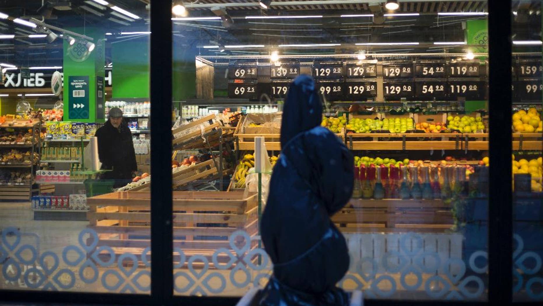 FILE - In this file photo taken on Tuesday, Jan. 19, 2016, an elderly man, left, looks around at a supermarket in Moscow, Russia. The World Bank has cut its growth forecasts for the Russian economy, predicting it will contract 1.9 percent this year due to low oil prices and international sanctions, and warns of a rise in poverty. (AP Photo/Alexander Zemlianichenko, file)