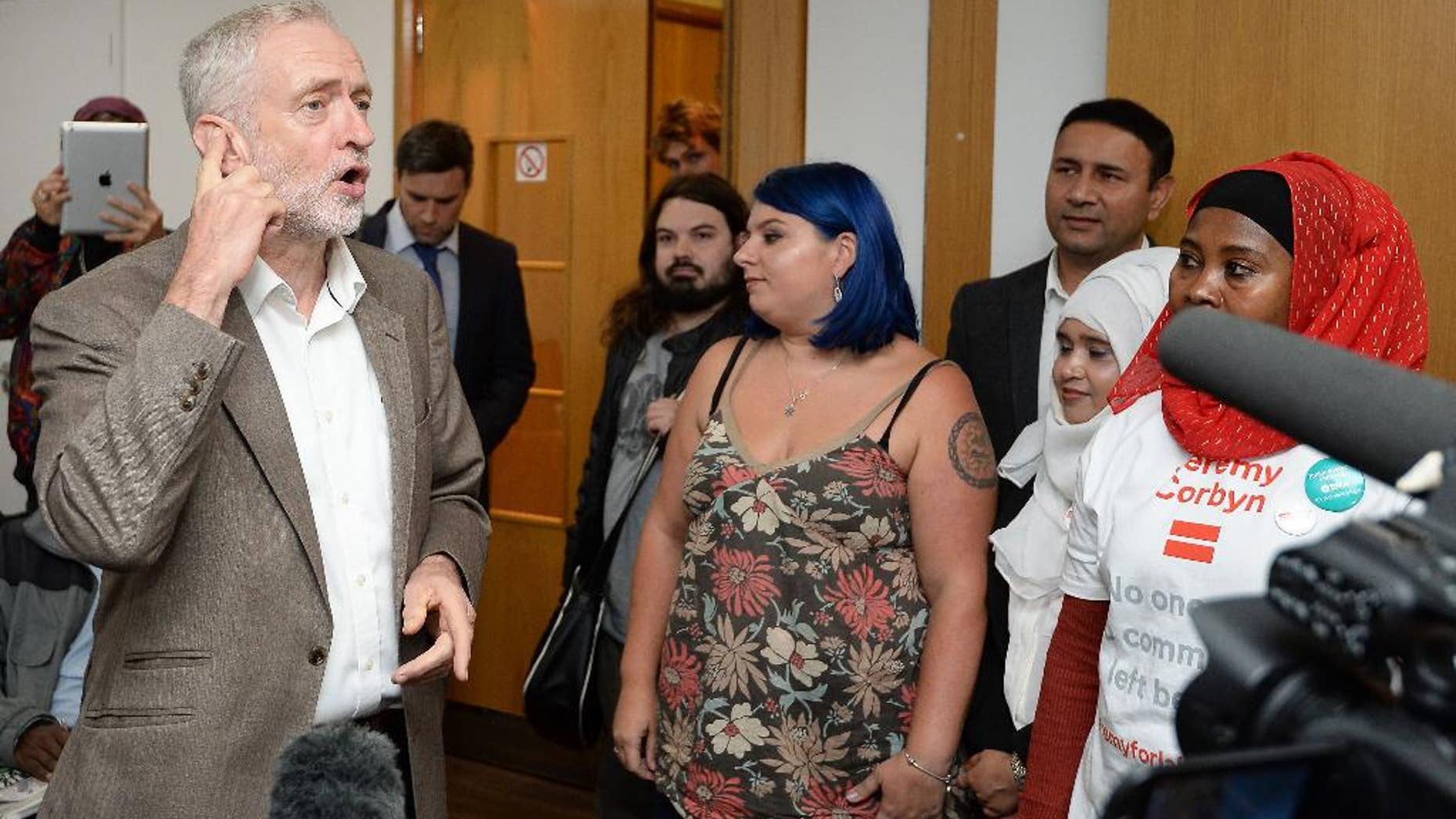 Britain's Labour Party leader Jeremy Corbyn, left, at a rally for party members phoning people for their support of Corbyn in the leadership election, at the Unison headquarters in central London, Tuesday, Sept. 20, 2016. (John Stillwell/PA via AP)