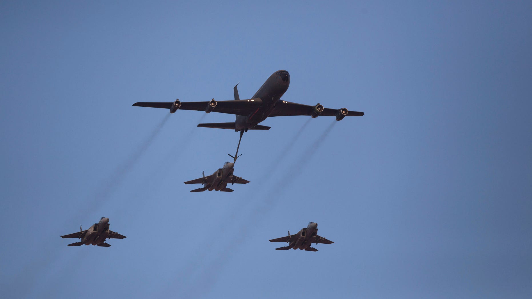 File - In this June 27, 2013 file photo, an Israeli Air Force Boeing 707 refuels three F15I fighter jets during an acrobatics display during a graduation ceremony in the Hatzerim air force base near the southern city of Beersheba, Israel. In an apparent message to Iran, the Israeli military said Thursday, Oct. 10, 2013, it had carried out a “special long-range flight exercise”. The military said its squadrons practiced refueling planes in midair this week and tested the air force’s ability. The accompanying footage shows a tanker plane refueling a fighter jet midair, a key part of any long-range operation. (AP Photo/Ariel Schalit, File)