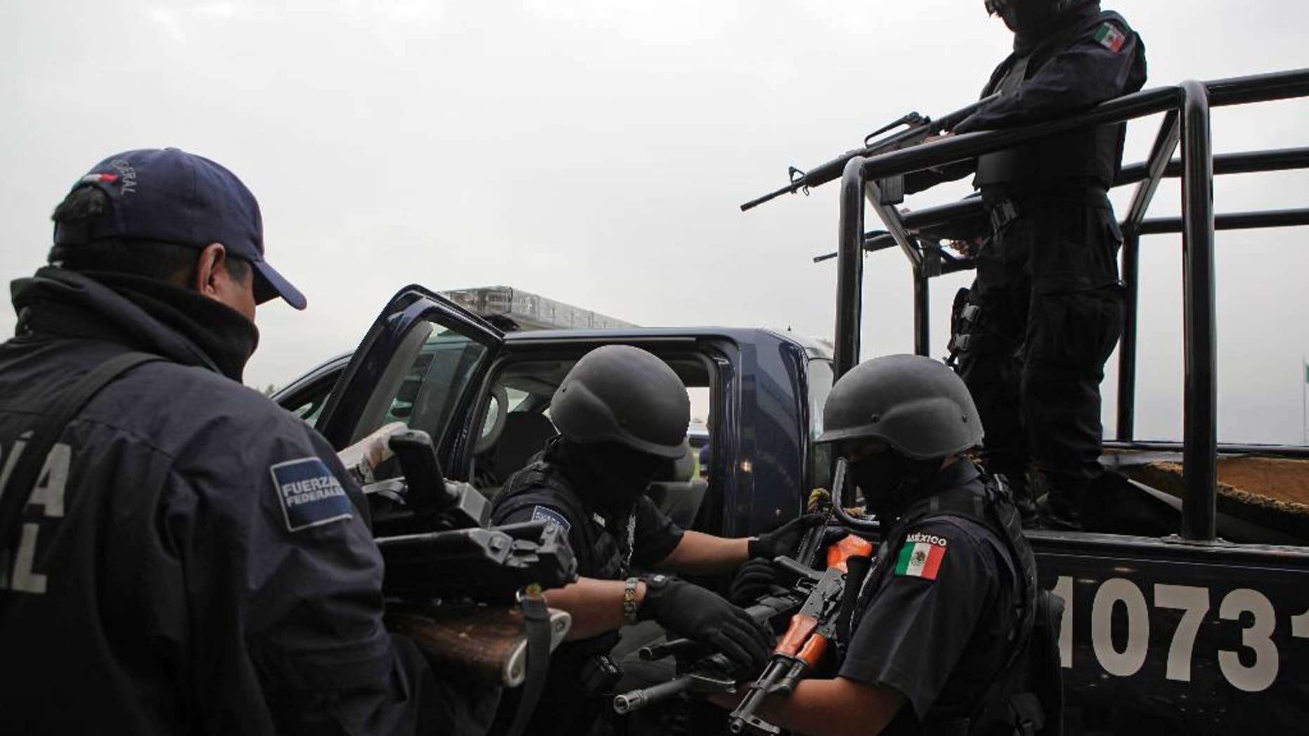 FILE - In this June 26, 2009 file photo, seized weapons from alleged members of the Beltran Leyva drug cartel are taken away by federal agents after a press conference in Mexico City. In a major embarrassment for Mexican law enforcement, U.S. prosecutors said in documents made public Wednesday, April 6, 2017, that Ivan Reyes Arzate, the commander of the Mexican police's intelligence-sharing unit, was passing information to the Beltran Leyva drug cartel in exchange for cash. (AP Photo/Alexandre Meneghini, File)