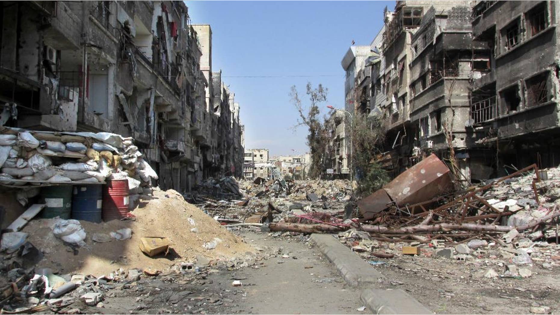 This picture taken on Monday Feb. 24, 2014, and released by the United Nations Relief and Works Agency for Palestine Refugees in the Near East (UNRWA), shows damage and debris on one of the main streets of the besieged Palestinian camp of Yarmouk, in Damascus, Syria. U.N. Secretary General Ban Ki-Moon urged Syrian government to authorize more humanitarian staff to work inside the country, devastated by its 3-year-old conflict. (AP Photo/UNRWA)