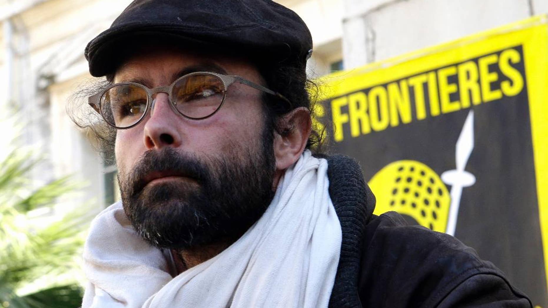 FILE - In this Wednesday, Jan. 4, 2017 file picture, Cedric Herrou, a French activist farmer who faces up to five years in prison as he goes on trial accused of helping African migrants cross the border from Italy, waits outside the Nice courthouse, southern France. Cedric Herrou remains defiant: Ahead of a court ruling that could see him jailed for sheltering migrants, the French activist has more arrivals from Africa staying on his farm. (AP Photo/Claude Paris, File)