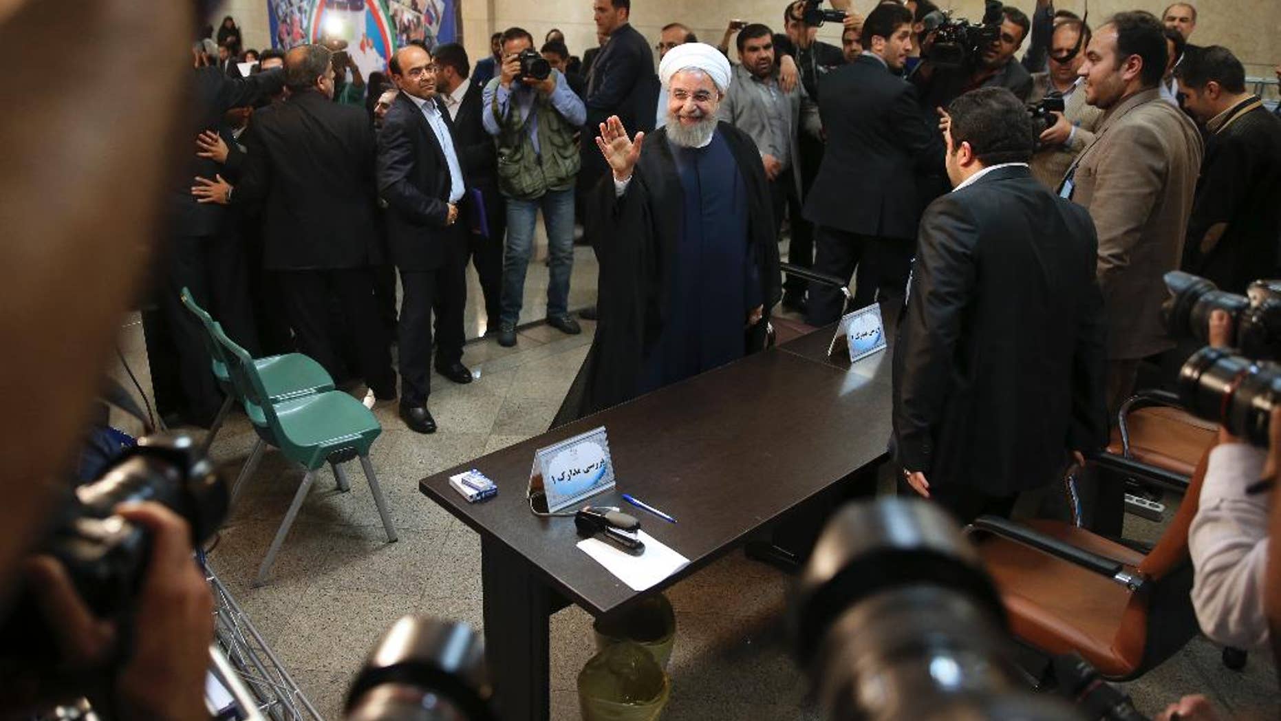 Iranian President Hassan Rouhani waves to media as he arrives at the Interior Ministry to register his candidacy for the May 19 presidential elections, in Tehran, Iran, Friday, April 14, 2017. (AP Photo/Vahid Salemi)
