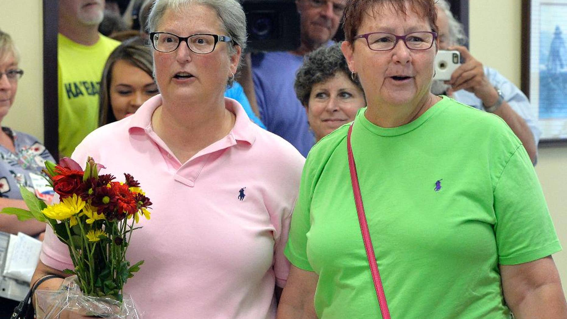 April Miller, left, and her partner Karen Roberts arrive to obtain their marriage license at the Rowan County Judicial Center in Morehead, Ky., Friday, Sept. 4, 2015. Miller, one of the plaintiffs in the suit against Rowan County Clerk Kim Davis, applied for her license with her partner less than 24 hours after Davis was jailed on contempt charges. (AP Photo/Timothy D. Easley)