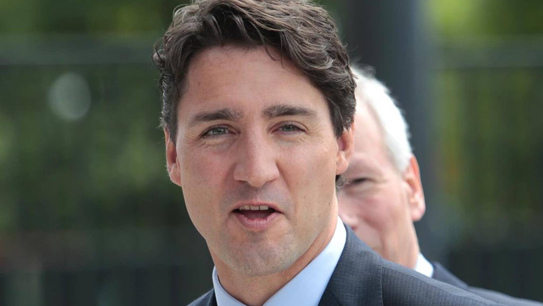 FILE - In a Friday, July 8, 2016 file photo, Canadian Prime Minister Justin Trudeau arrives at the NATO summit in Warsaw, Poland. Sightings of a shirtless Trudeau are causing something of a stir across Canada and internationally this summer. The prime minister was most recently photographed shirtless Saturday, Aug. 6, 2016, while taking a break from surfing and simultaneously photobombing a couple getting married on a Tofino, B.C., beach. (AP Photo/Markus Schreiber, File)