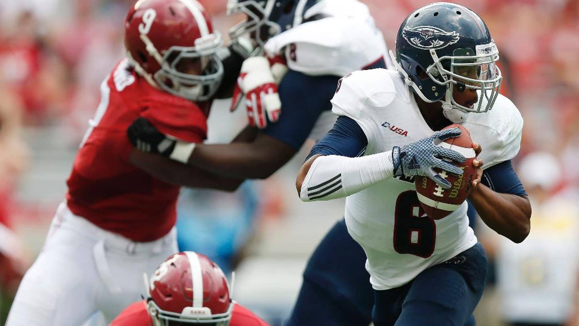 Florida Atlantic quarterback Greg Hankerson (6) slips through Alabama defense and looks to pass during the second half of an NCAA college football game Saturday, Sept. 6, 2014, in Tuscaloosa, Ala. (AP Photo/Brynn Anderson)