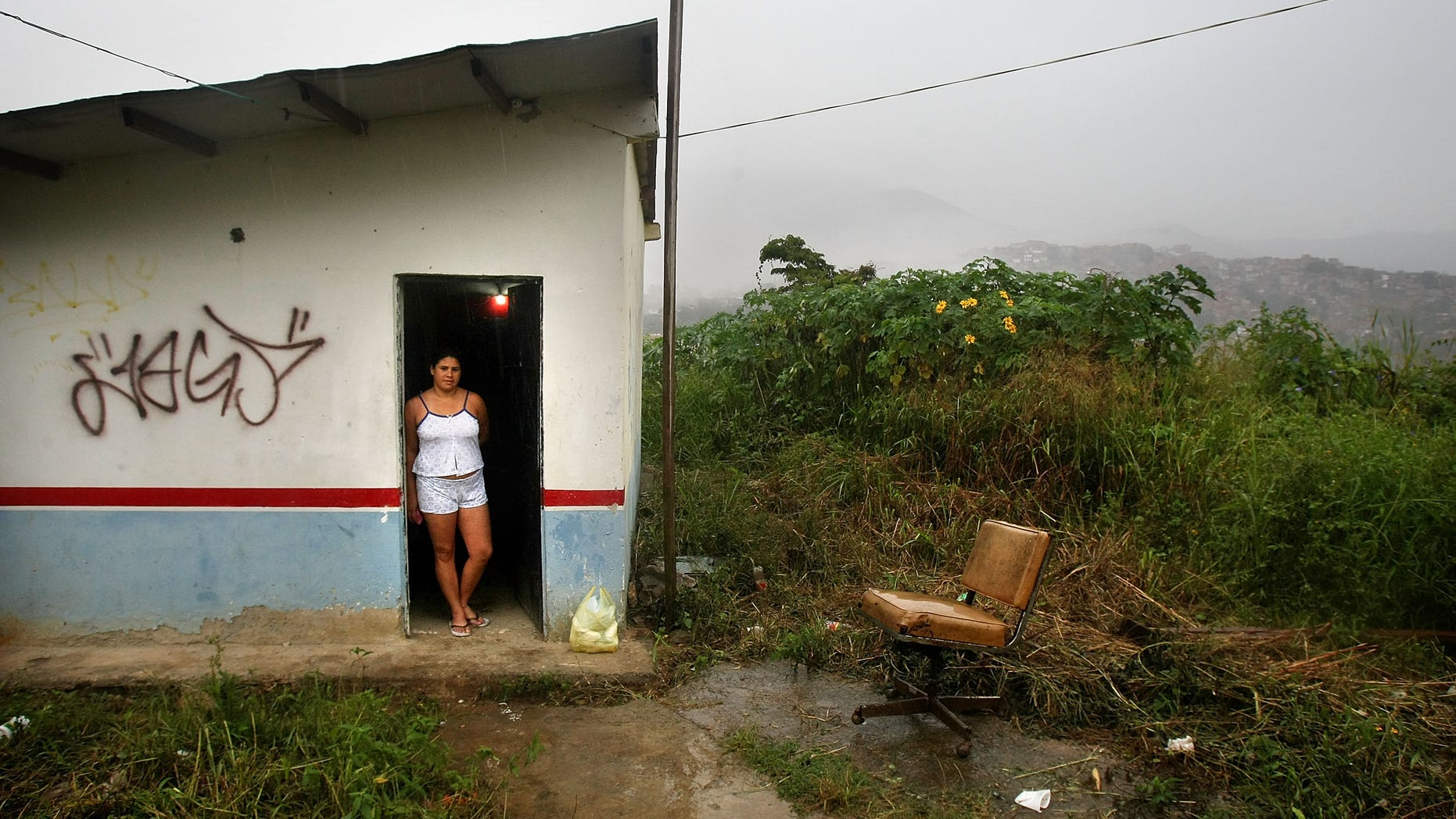 Carolina Olivera stands in her front door in the poor barrio of Petare in Caracas, Venezuela.