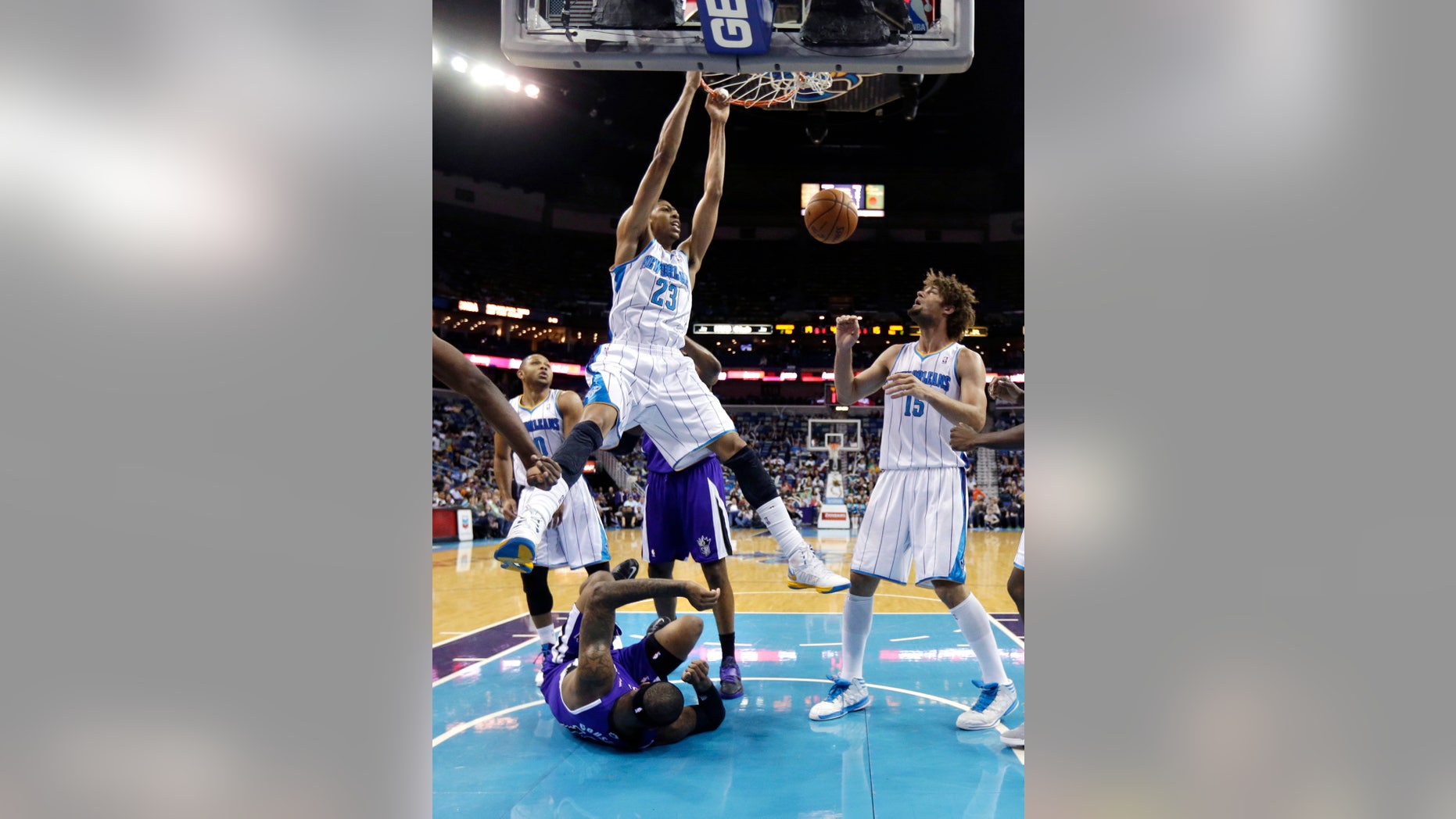 New Orleans Hornets power forward Anthony Davis (23) dunks over Sacramento Kings center DeMarcus Cousins, on the court, during the first half of an NBA basketball game in New Orleans, Sunday, Feb. 24, 2013. At right is Hornets center Robin Lopez (15). (AP Photo/Gerald Herbert)