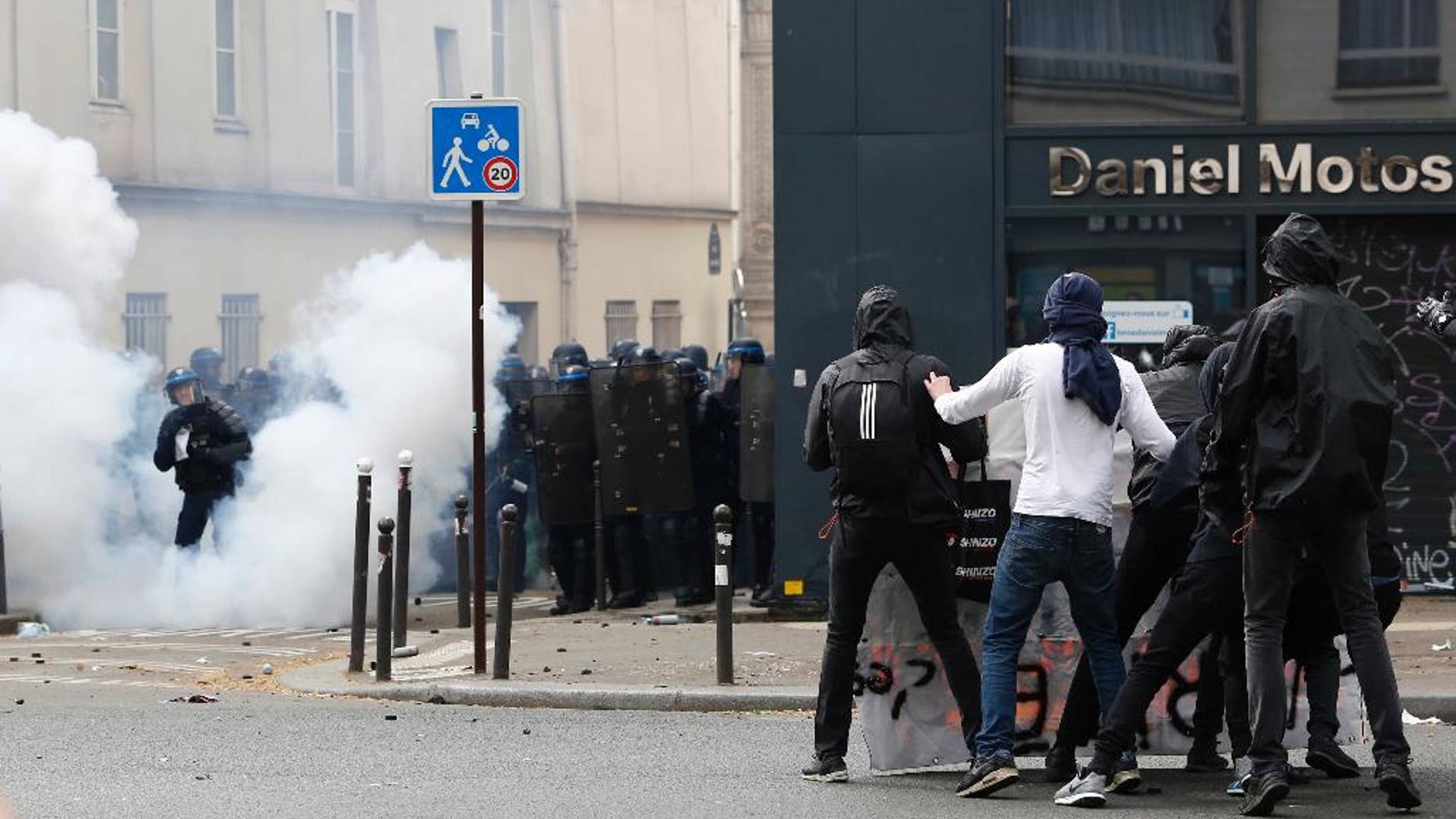 Youth, right, face French riot police officers during the May Day demonstration, Monday May 1, 2017, in Paris. Paris police are firing tear gas at rowdy protesters on sidelines of May Day workers' march. (AP Photo/Kamil Zihnioglu)