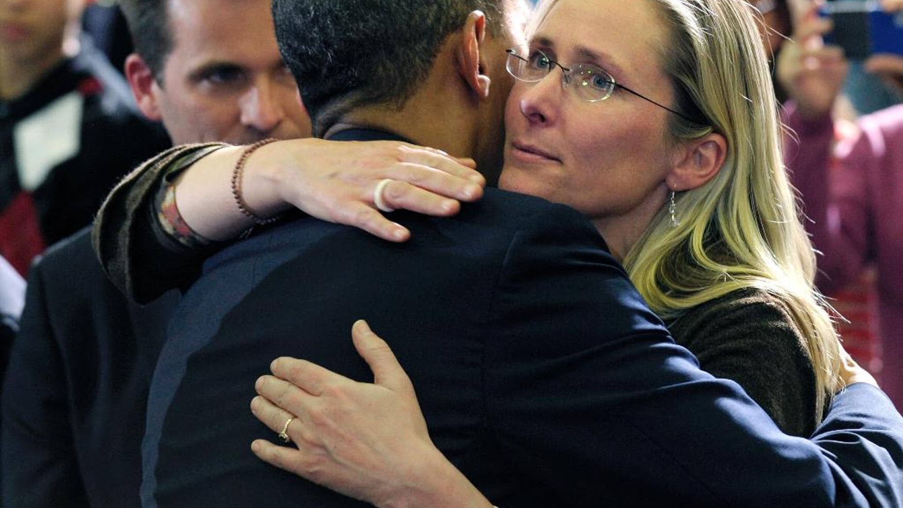 FILE - In this April 8, 2013, file photo, President Barack Obama embraces Scarlett Lewis, mother of Sandy Hook Elementary School shooting victim Jesse Lewis, after speaking at in Hartford, Conn. Through his death in a gun battle with police on Sunday, June 12, 2016, the Orlando nightclub gunman deprived his victims' families of the chance for a trial that could have helped to channel grief, offer a sense of justice or provide answers for the bloodshed. In Newtown, Conn., where the gunman took his own life after killing 26 people inside the school in December 2012, Lewis said his survival only would have made it more difficult as she grieved for her murdered son, Jesse. (AP Photo/Susan Walsh, File)