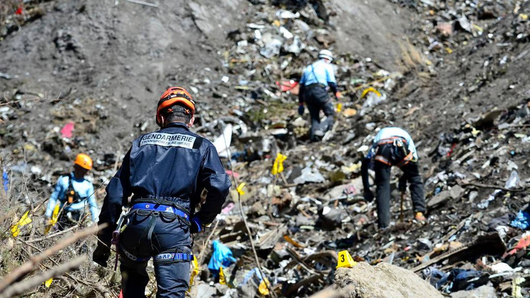 In this undated photo provided by the French Interior Ministry, French emergency rescue services work at the site of the Germanwings jet that crashed on Tuesday, March 24, 2015 near Seyne-les-Alpes, France. The co-pilot of the Germanwings jet barricaded himself in the cockpit and intentionally rammed the plane full speed into the French Alps, ignoring the captain's frantic pounding on the door and the screams of terror from passengers, a prosecutor said Thursday. (AP Photo/French Interior Ministry, Francis Pellier)