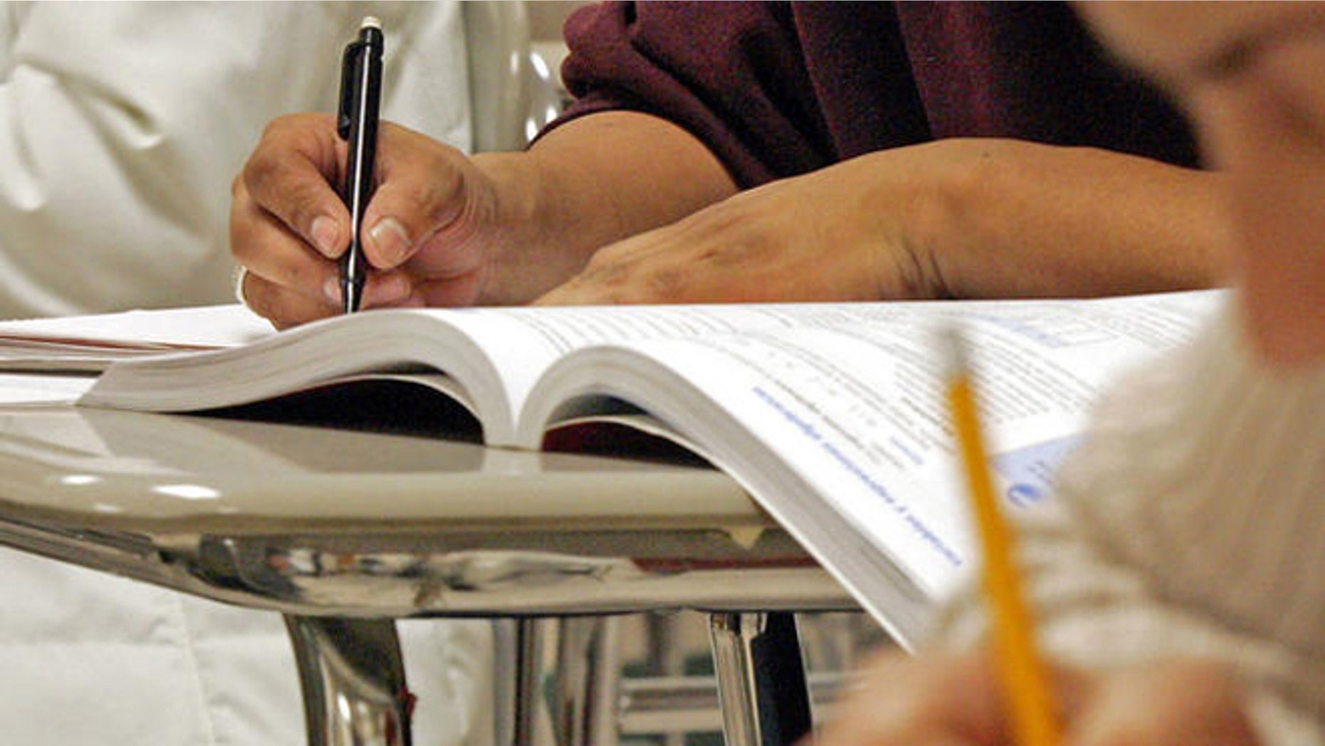 Students work out math problems during a class for Hispanic adults, Wednesday, March 16, 2005, at Cary High School in Cary, N.C. Even among Hispanics 16-to-19 who were educated entirely in the United States, 15 percent nationally are dropouts, compared with 12 percent for blacks and 8 percent for whites. (AP Photo/ Karl DeBlaker)