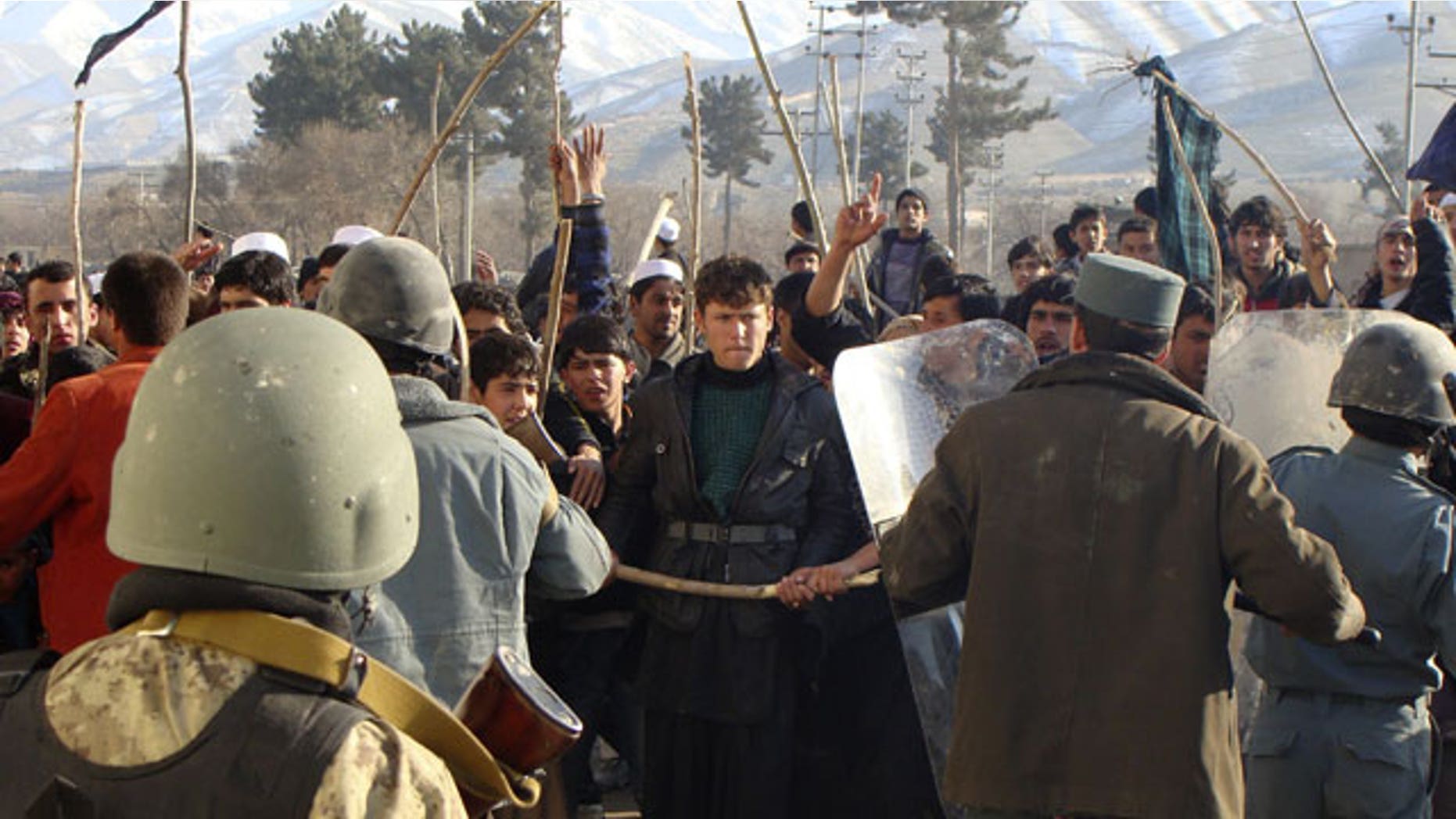 Feb. 24, 2012: Afghan police tries to restrain demonstrators during an anti-US protest in Baghlan province, north of Kabul, Afghanistan.