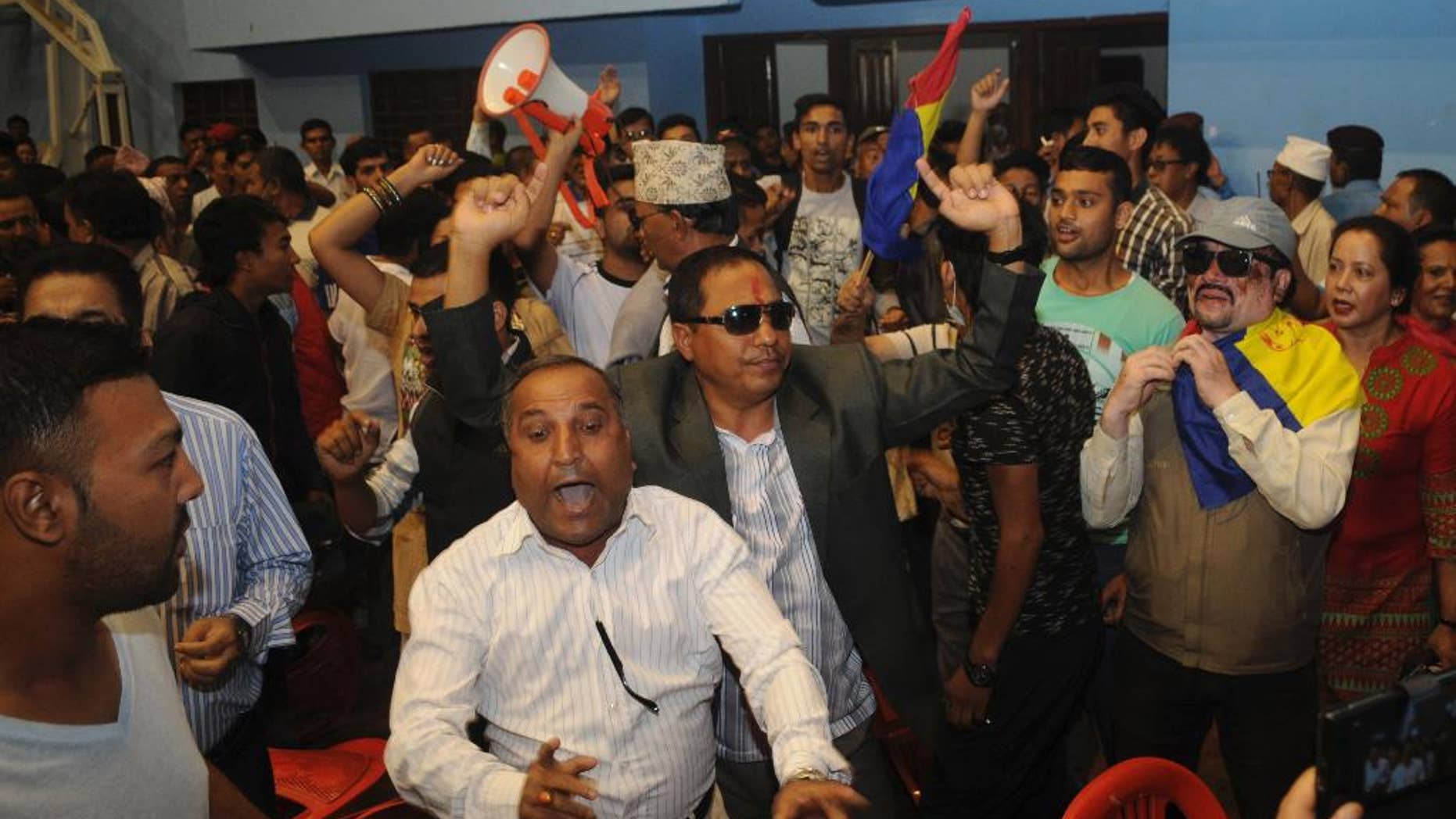 Protestors from Rastriya Prajatantra Party Nepal shout slogans after storming into the national stadium where Deputy Prime Minister Prakash Man Singh was collecting suggestions on a draft constitution in Kathmandu, Nepal, Monday, July 20, 2015. Protesters demanding that Nepal be turned back into a Hindu nation scuffled with police Monday and threw chairs at the country's deputy prime minister. (AP Photo/ Dipesh Shreshta)