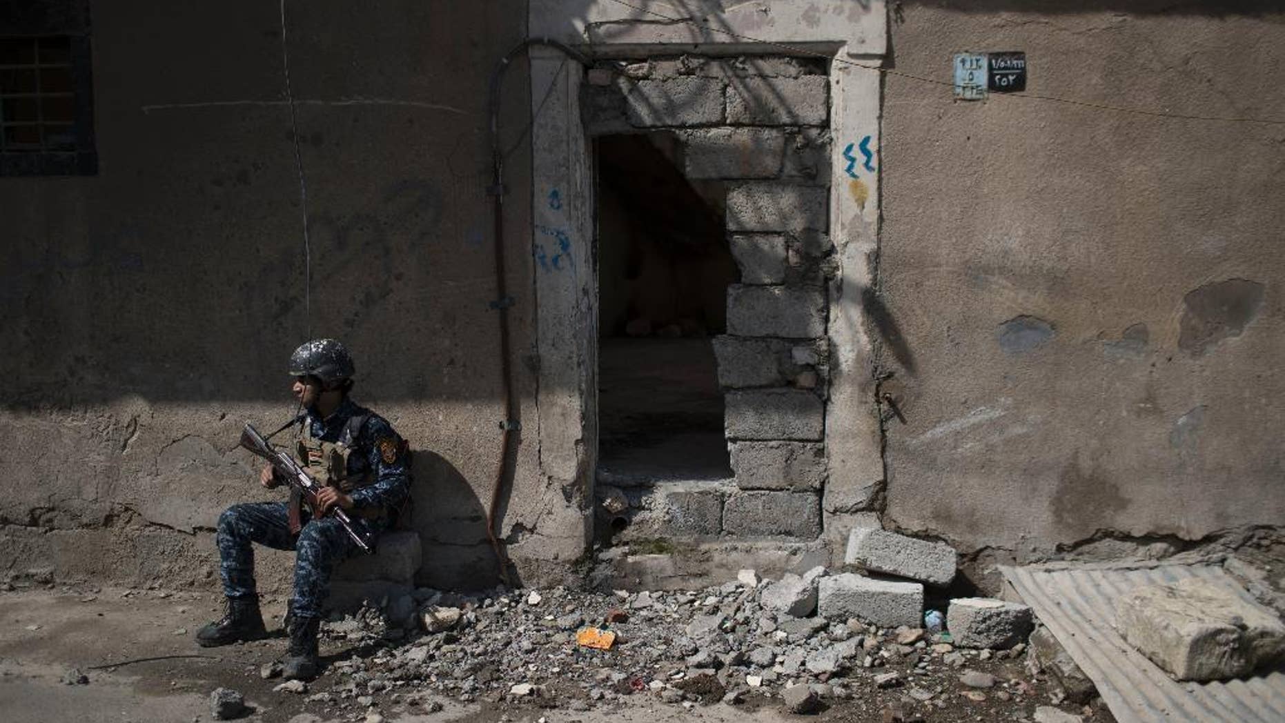 A federal policeman takes a break from inspecting houses during fighting against Islamic State militants on the western side of Mosul, Iraq, Wednesday, March 29, 2017. (AP Photo/Felipe Dana)