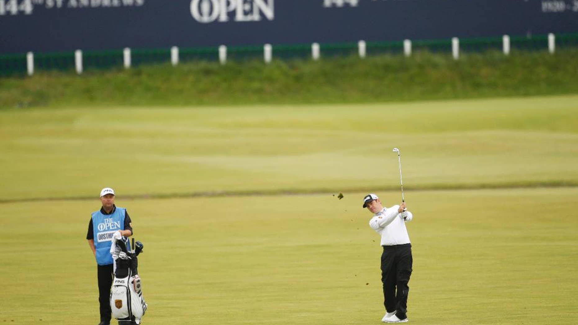 South Africa's Louis Oosthuizen, right, plays his second shot on the 1st hole at the Old Course, St Andrews, Scotland, Monday, July 13, 2015. Louis Oosthuizen played a practice round ahead of the 2015 Open Golf Championship that is due to take place at St. Andrews July16-19. (AP Photo/Peter Morrison)