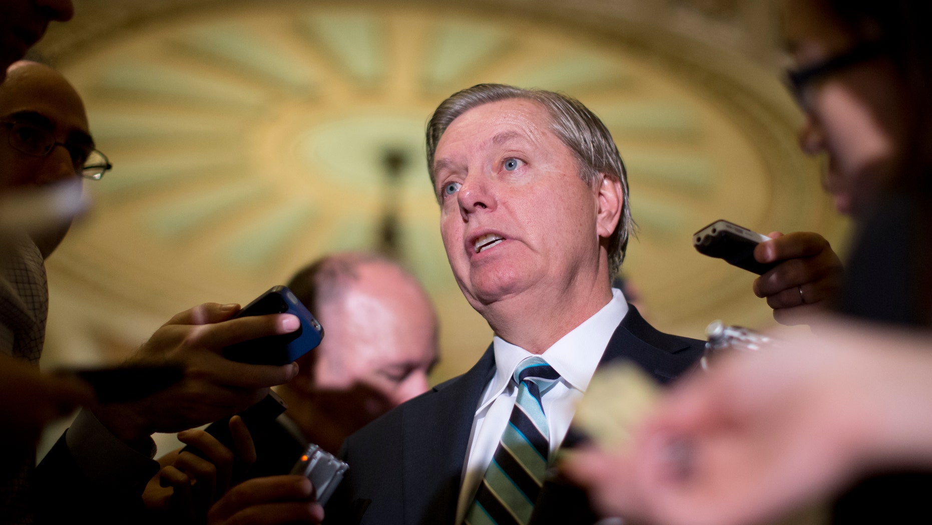 FILE - In this Oct. 16, 2013, file photo, Sen. Lindsey Graham, R-S.C., speaks with reporters on Capitol Hill in Washington. Graham threatened Monday, Oct. 28, to hold up all nominations for federal government positions until survivors of last year's deadly attack on the diplomatic post in Libya appear before Congress. (AP Photo/Carolyn Kaster, File)