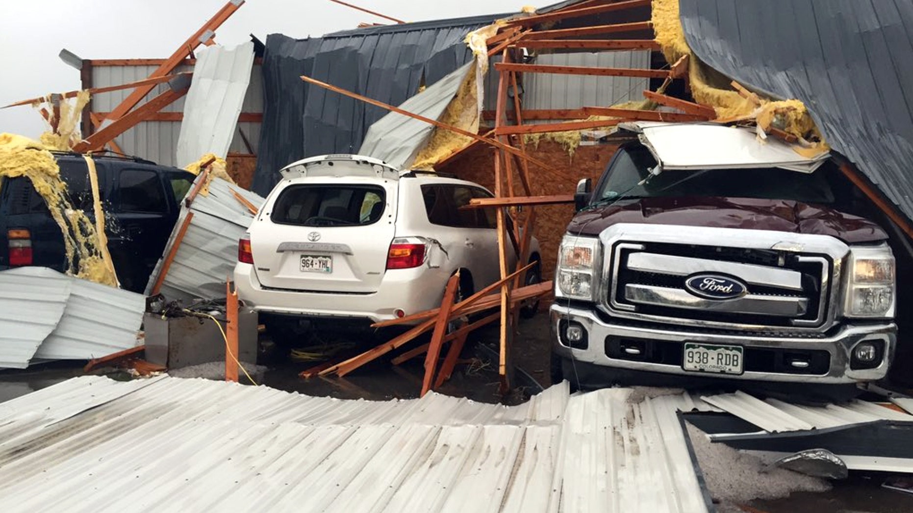 Debris lies on damaged vehicles after a tornado was reported in Weld County outside Wiggins, Colo., Saturday, May 7, 2016. Spring storms menaced parts of the West on Saturday, bringing hail and a tornado sighting in Colorado and deadly driving conditions in Arizona. (Kristen Skovira/KMGH-Channel 7 via AP) MANDATORY CREDIT