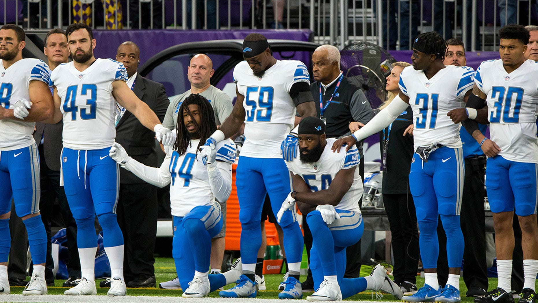 Detroit Lions players kneel while others stand during the national anthem before the game against the Minnesota Vikings.