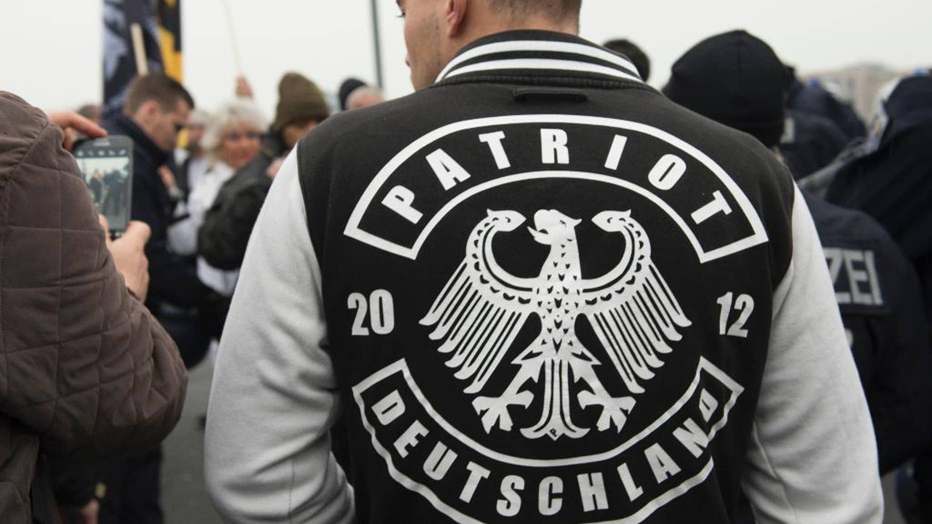 A demonstrator wears a jacket with the writing "Patriot Deutschland" (lt. Germany Patriot) during the fourth demonstration of the right-wing populist alliance 'Wir fuer Deutschland' in Berlin, Germany, Saturday, Nov. 5, 2016. (Paul Zinken/dpa via AP)