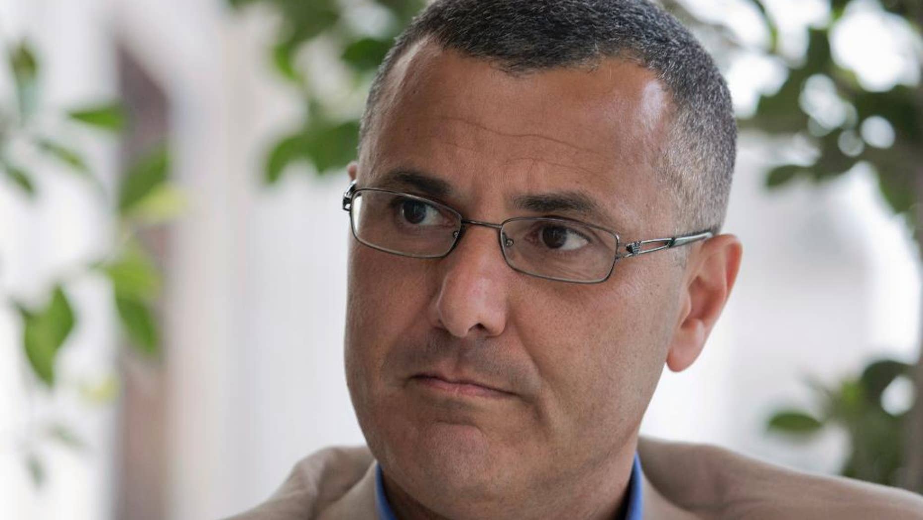 Omar Barghouti listens during an interview with the Associated Press in the West Bank city of Ramallah, Tuesday, May 10, 2016. Barghouti, a Qatari-born Palestinian who is married to an Israeli woman and leader of the international boycott movement against Israel, on Tuesday accused Israeli authorities of imposing a travel ban on him as retribution for his political activities. (AP Photo/Nasser Nasser)