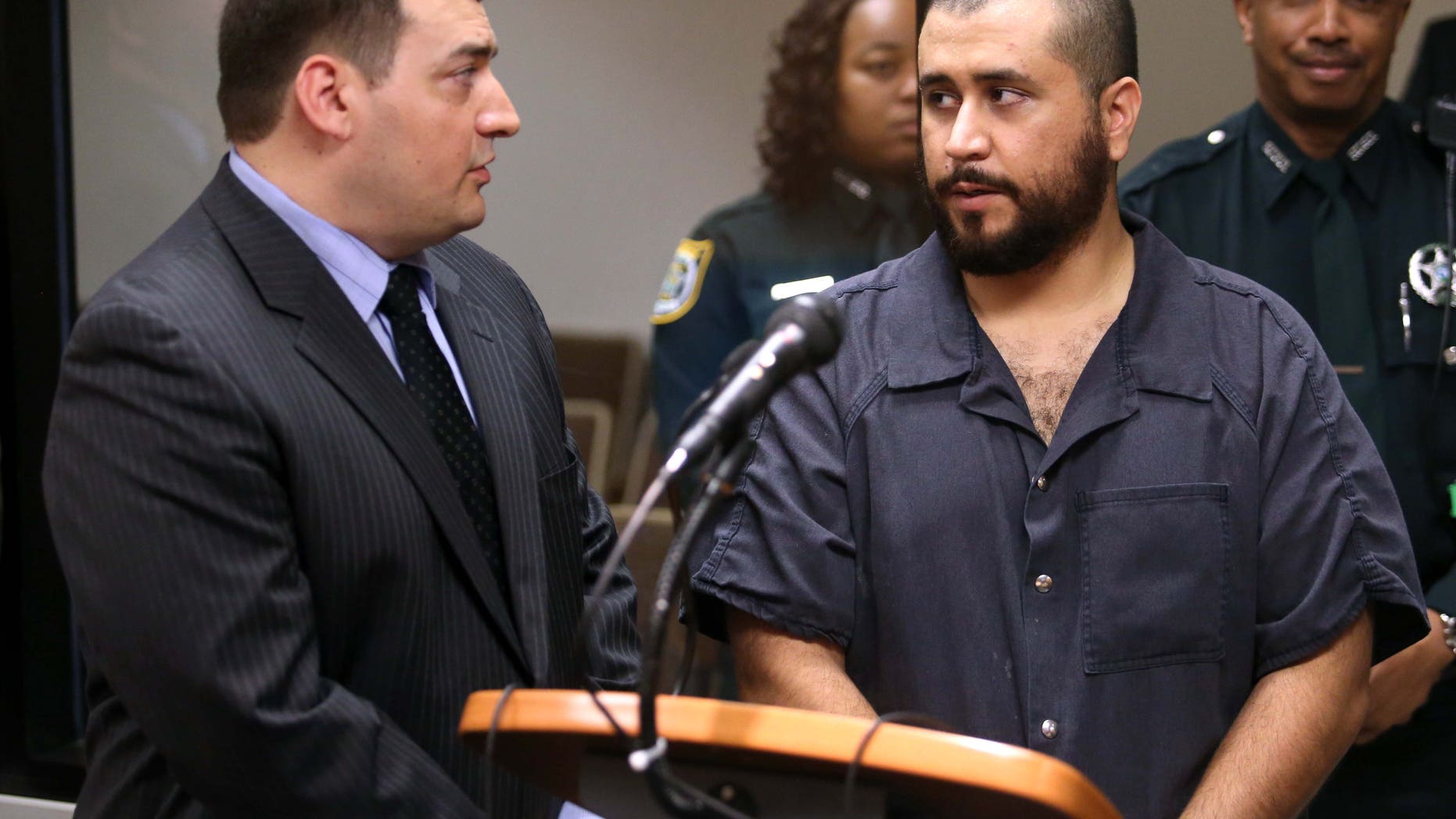 George Zimmerman, acquitted in the high-profile killing of unarmed black teenager Trayvon Martin, talks to defense counsel Daniel Megaro, left, Tuesday, Nov. 19, 2013, in Sanford, Fla., during Zimmerman's hearing on charges including aggravated assault stemming from a fight with his girlfriend. (AP Photo/Orlando Sentinel, Joe Burbank, Pool)