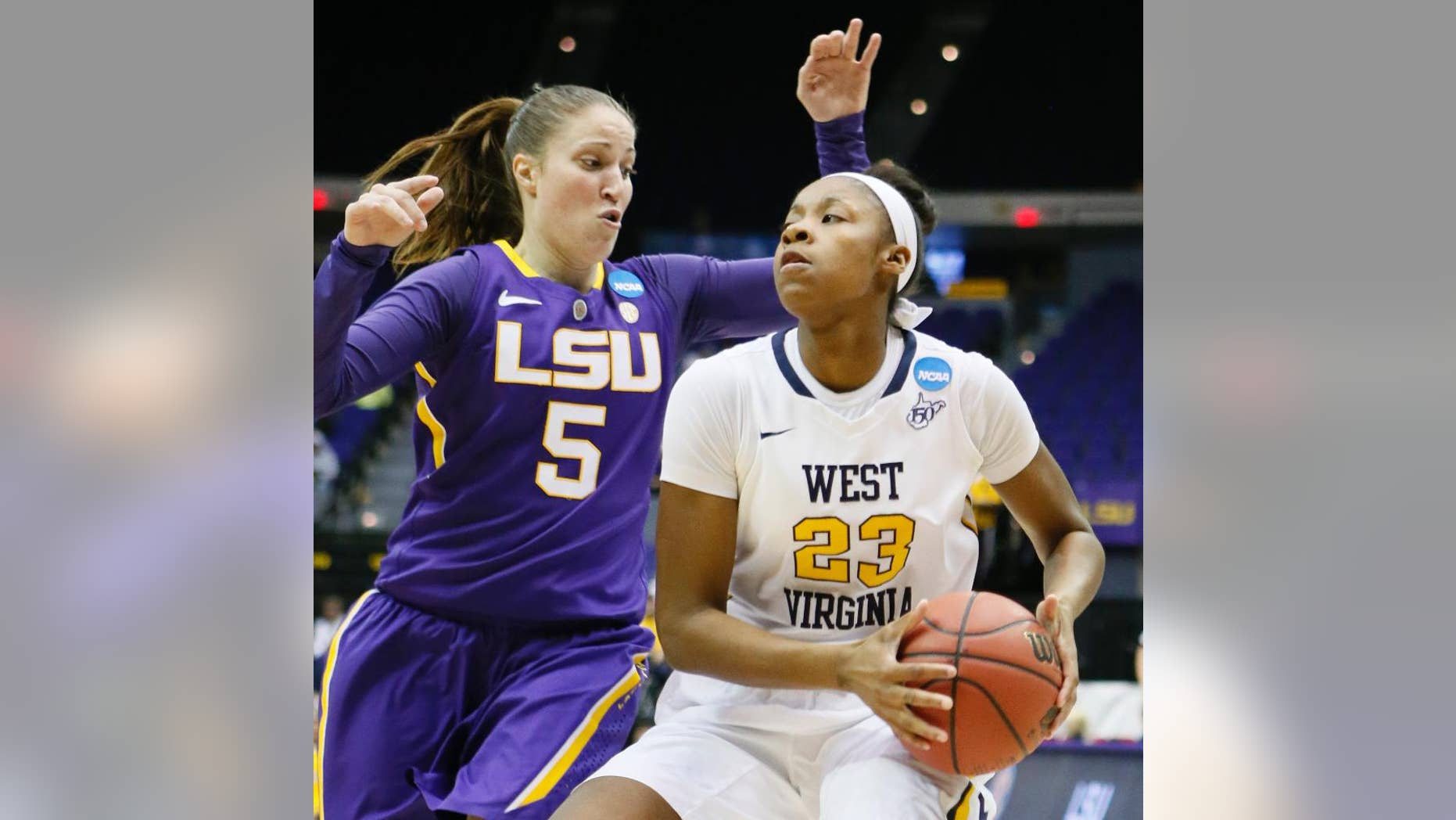 West Virginia guard Bria Holmes (23) looks for an opening to the goal as LSU guard Jeanne Kenney (5) defends in the first half of an NCAA college basketball second-round tournament game Tuesday, March 25, 2014, in Baton Rouge, La. (AP Photo/Rogelio V. Solis)
