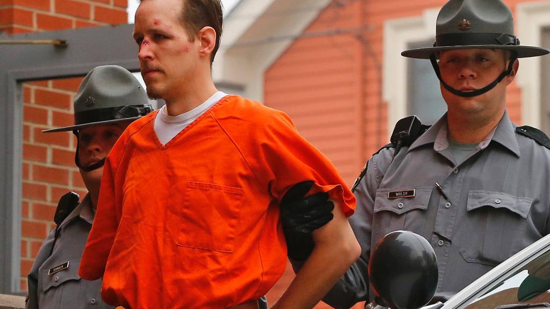 FILE - In this Oct. 31, 2014 file photo Eric Frein is escorted by police into the Pike County Courthouse for his arraignment in Milford, Pa. Frein a survivalist who eluded capture for 48 days after allegedly killing a trooper in a 2014 ambush says police were about a football field away from him at one point during the manhunt. Authorities say they found Eric Frein’s journal at the airplane hangar where he was hiding out until his arrest. A trooper testified about the journal at Frein’s capital murder trial Wednesday, April 12, 2017. (AP Photo/Rich Schultz, File)