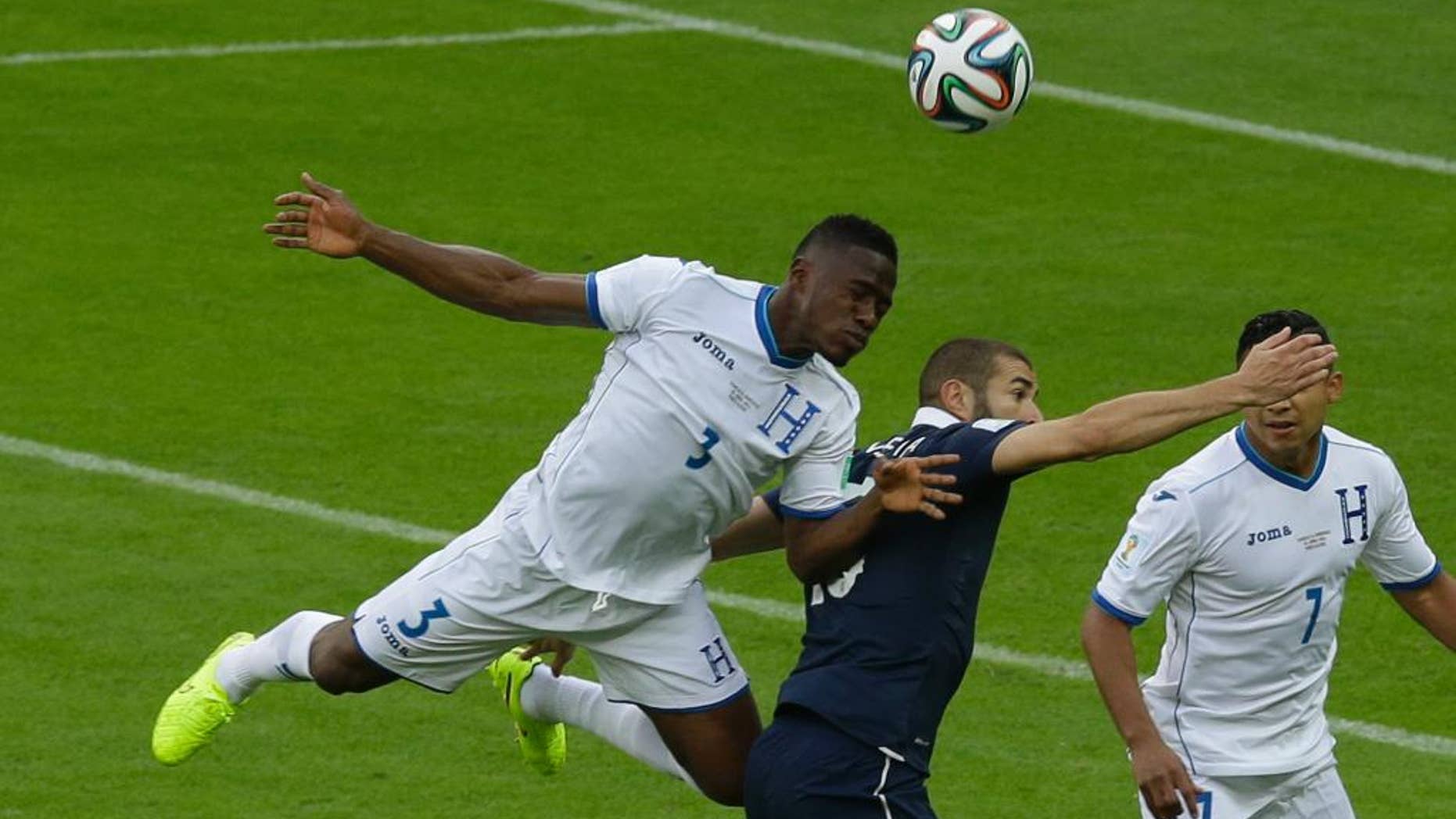 Honduras' Maynor Figueroa, left, and France's Karim Benzema challenge for the ball during the group E World Cup soccer match between France and Honduras at the Estadio Beira-Rio in Porto Alegre, Brazil, Sunday, June 15, 2014. (AP Photo/Andrew Medichini)