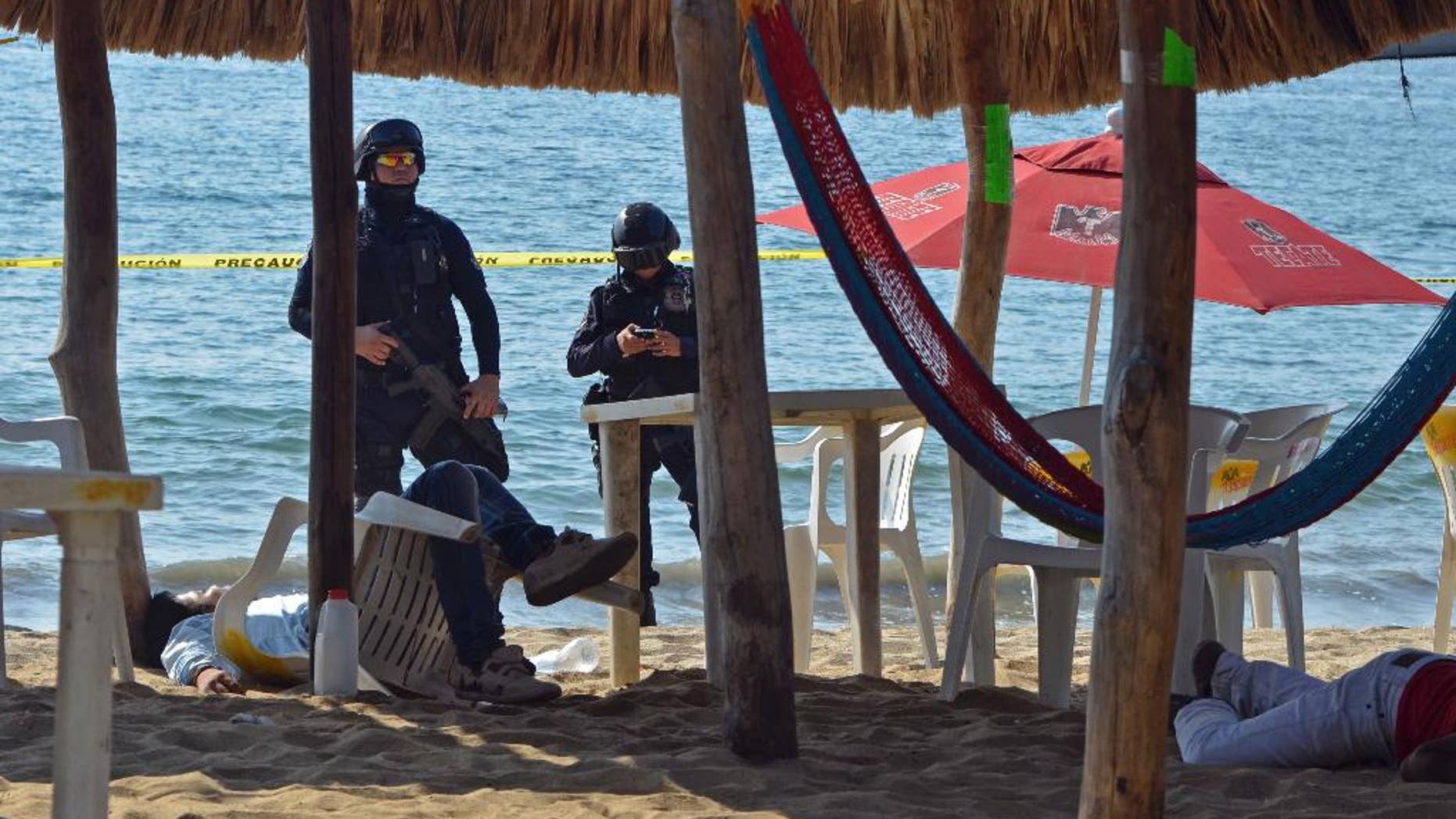 FILE - In this Jan. 6, 2017 file photo, state police inspect the site where two men were shot at the Tamarindos beach in the port city of Acapulco, Mexico. Mexico has surpassed 2,000 murders in a month for the first time since the summer of 2011, and had more murders in the first quarter of 2017 than in the start of any year in at least two decades, according to data released Friday, April 20, 2017. (AP Photo/Bernandino Hernandez, File)
