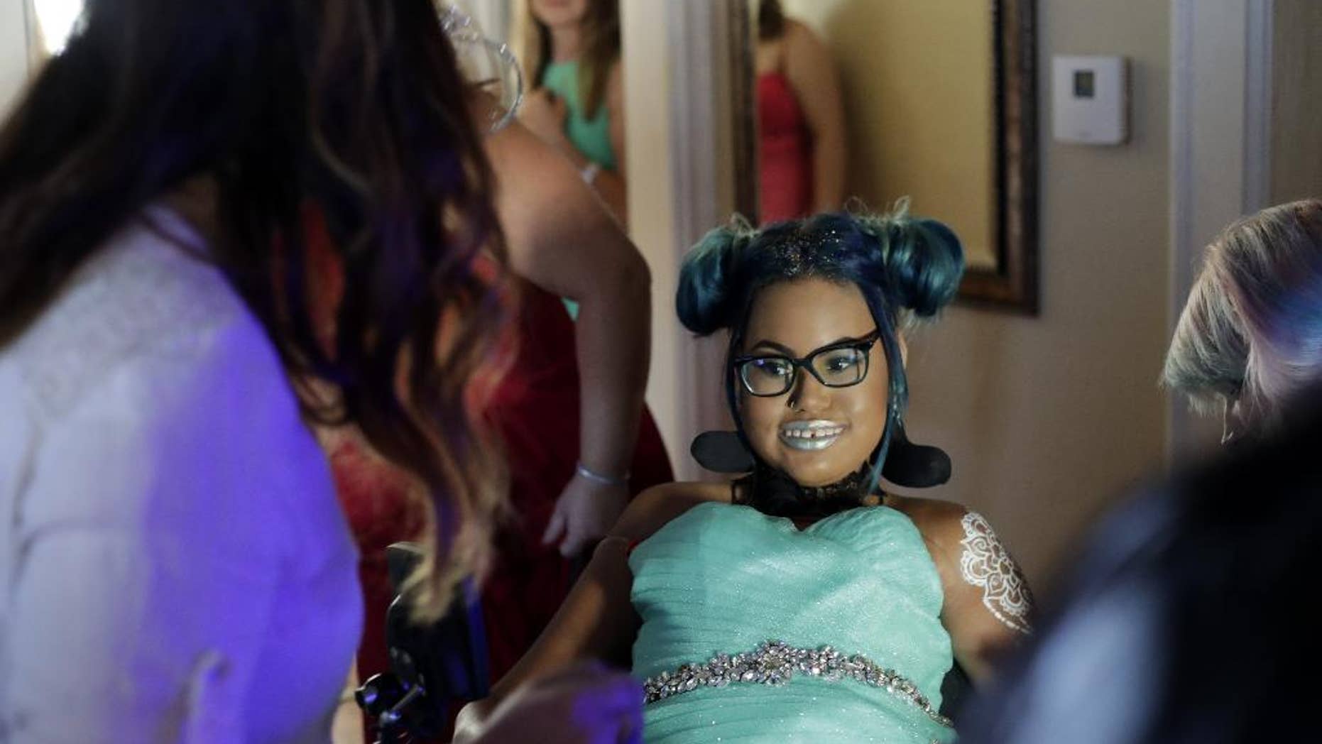 In this Friday, July 22, 2016 photo, Jerika Bolen goes through the final stages of hair and makeup before her prom at the Grand Meridian in Appleton, Wis. The ballroom was packed as well-wishers flooded in throughout the night to celebrate with the 14-year-old Appleton girl who suffers from a terminal illness and is expected to die by the end of summer. Dubbed “J’s Last Dance,” the prom was a final wish for Jerika, who has chosen to have her ventilator disconnected at the end of August because the chronic pain from her disease, spinal muscular atrophy type two, has become overwhelming and the prognosis is bleak. (Danny Damiani/The Post-Crescent via AP)