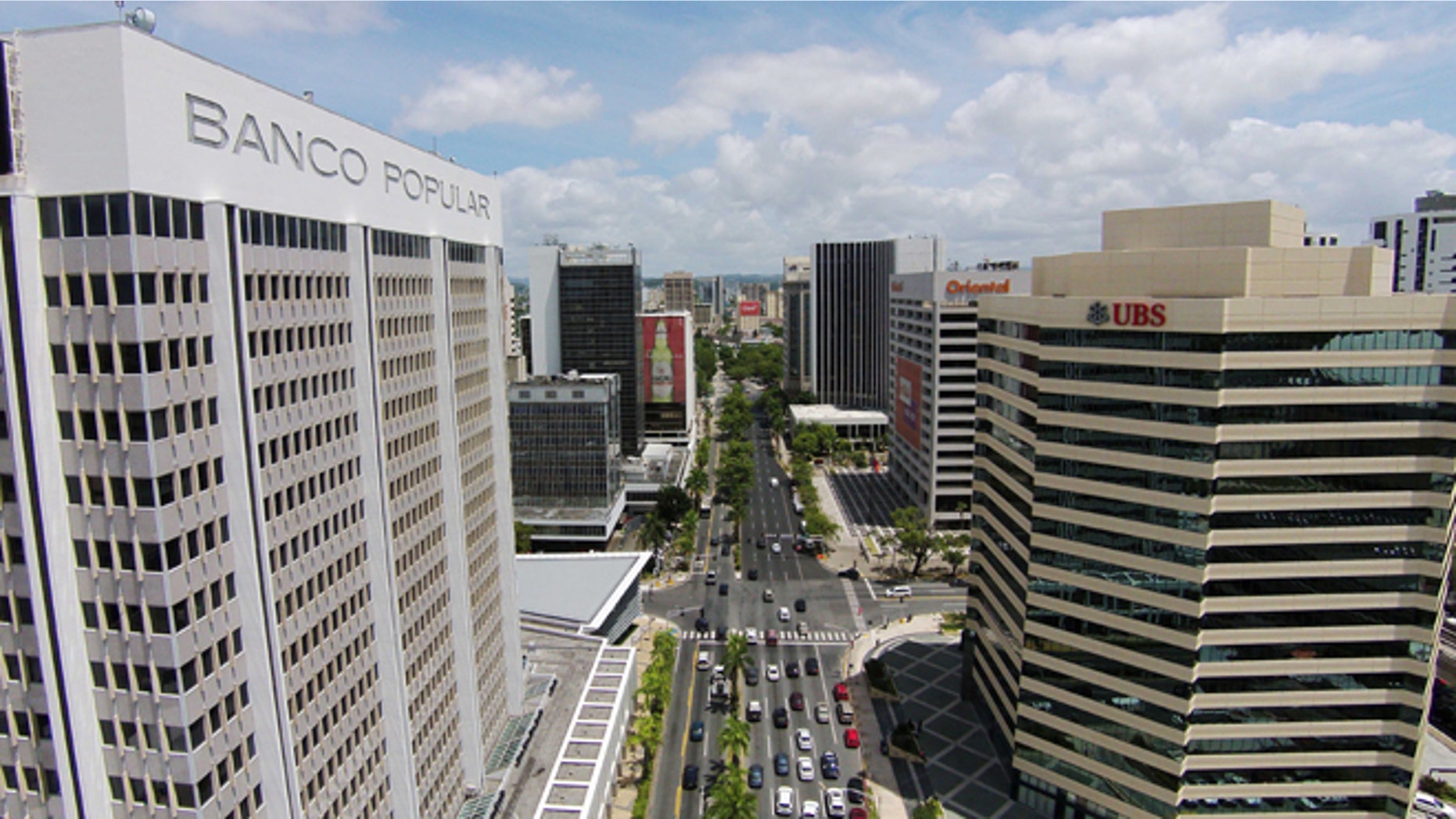 This July 16, 2014 photo shows the financial district in San Juan, Puerto Rico. Puerto Rico has seen a flurry of credit rating downgrades since the announcement of a law that allows some public corporations to restructure their debt if needed. The law was approved as the U.S. territory enters its eighth year in recession. (AP Photo/Ricardo Arduengo)