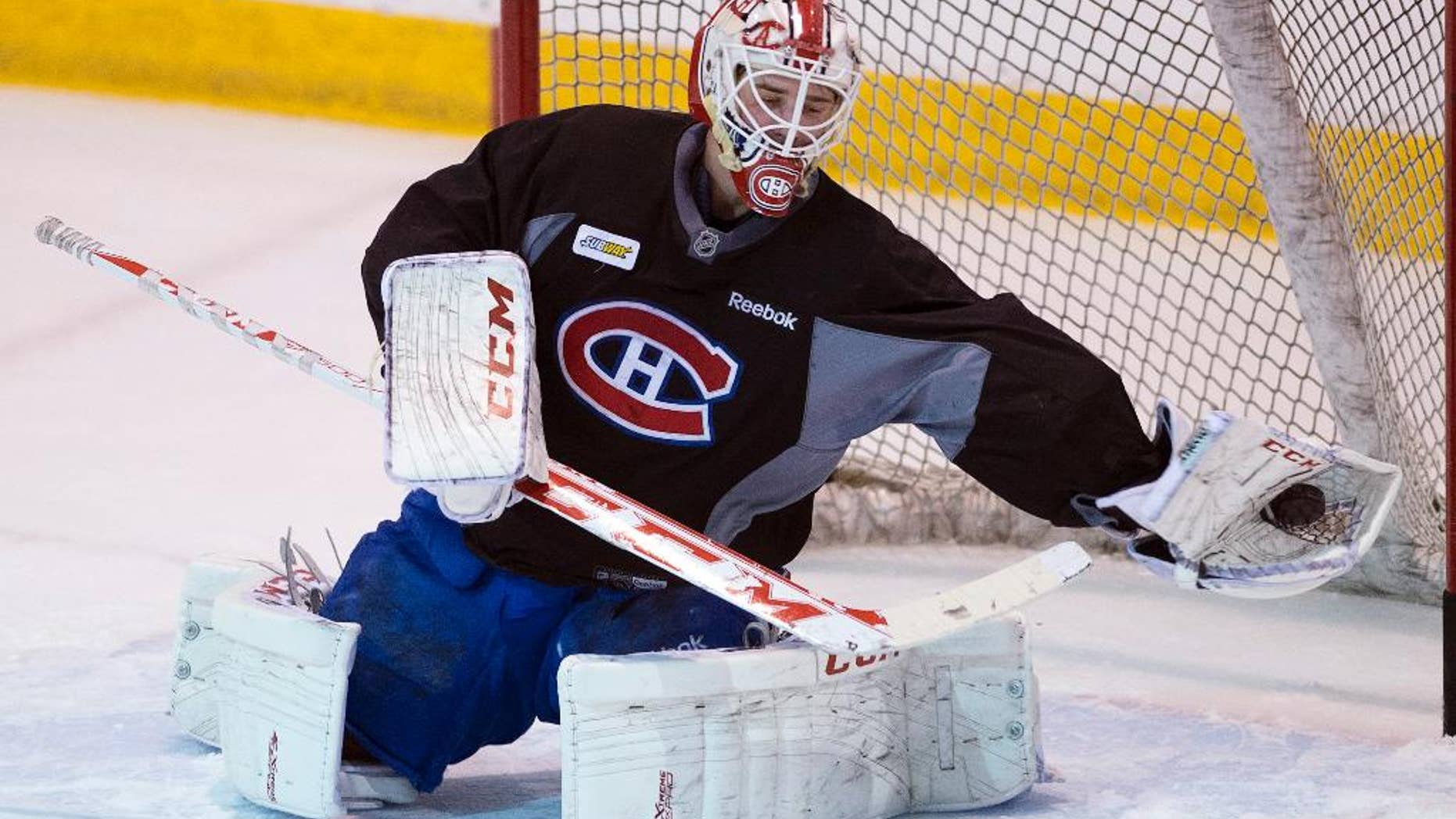 Montreal Canadiens goalie Dustin Tokarski makes a save during the team's practice Wednesday, May 21, 2014 in Brossard, Quebec. The Canadiens play the New York Rangers in Game 3 of the Eastern Conference final of the Stanley Cup Playoffs on Thursday in New York. (AP Photo/The Canadian Press, Ryan Remiorz)
