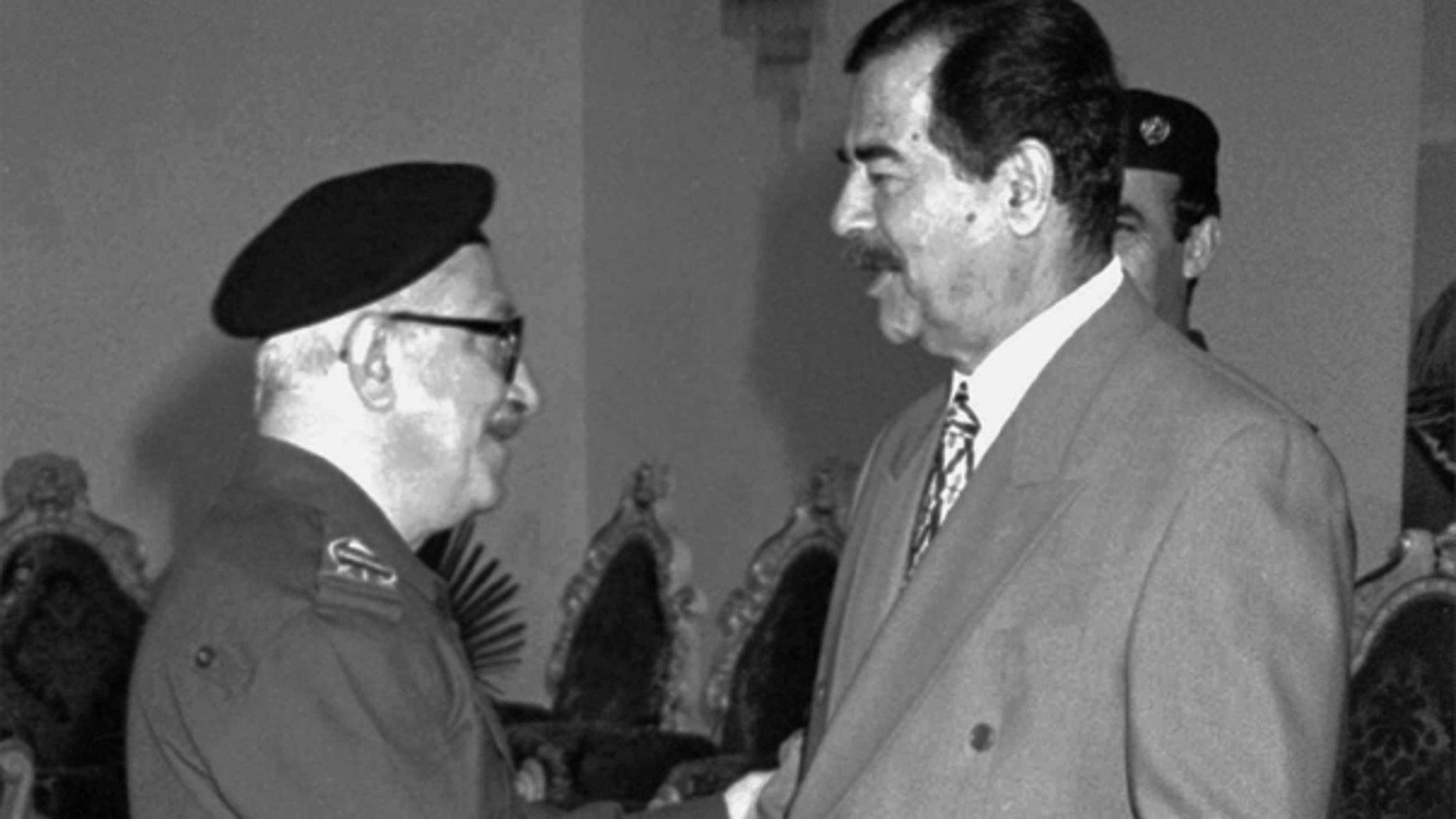 In this Jan. 29, 1998 file photo, Iraqi Deputy Premier Tariq Aziz, left, greets President Saddam Hussein on Eid al-Fitr, the end of Ramadan in Baghdad, Iraq.