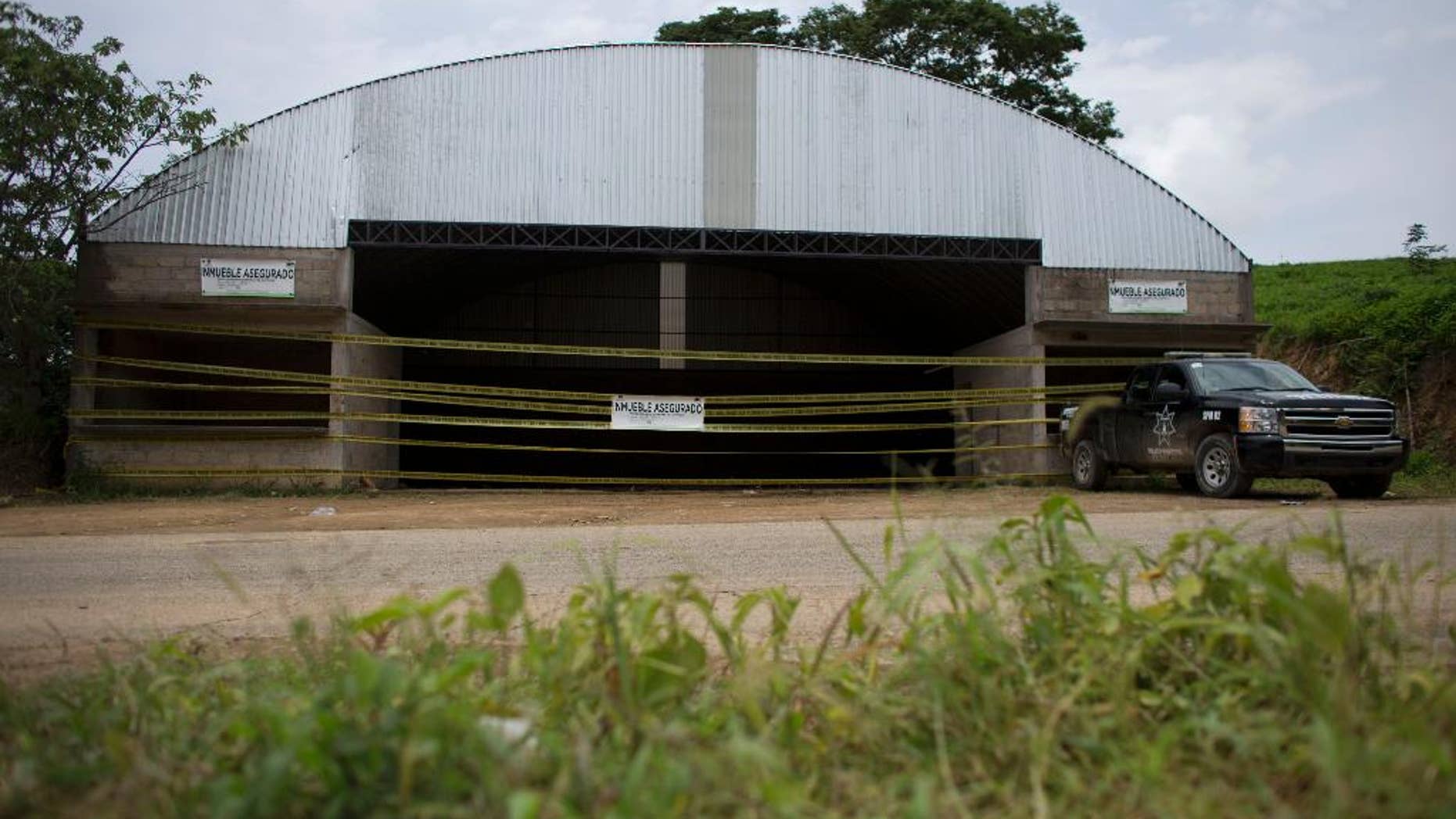 FILE - This July 3, 2014 file photo shows the warehouse where 22 alleged gang members were killed by soldiers on the outskirts of the village of San Pedro Limon, in Mexico state, Mexico. One year after soldiers executed as many as 15 suspects at a grain warehouse in southern Mexico, many say justice has still not been done. Human rights groups said Tuesday, June 30, 2015, the Mexican government must clear up the truth about what happened on June 30 2014. (AP Photo/Rebecca Blackwell, File)