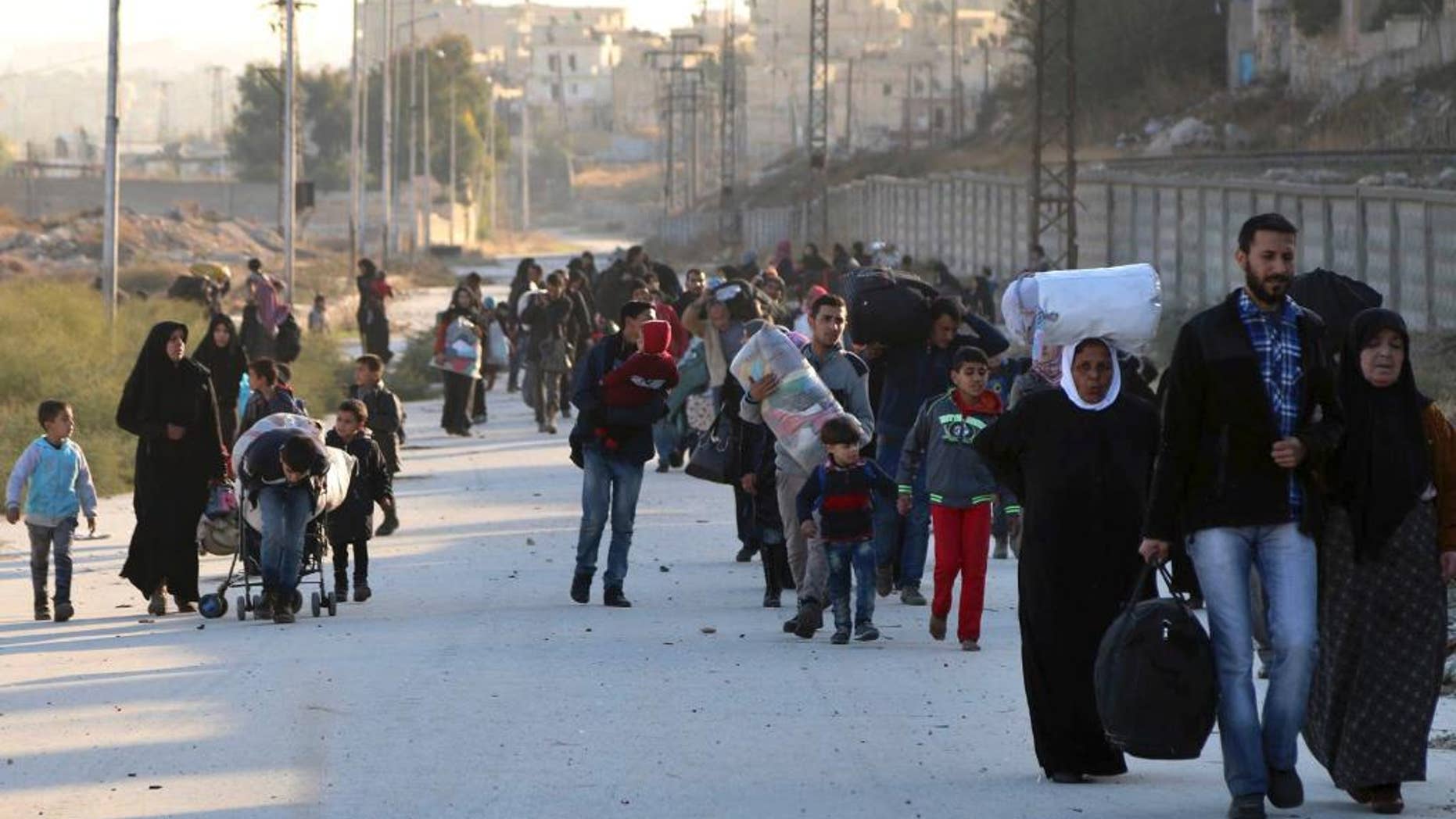 FILE - In this Sunday, Nov. 27, 2016 file photo provided by the Rumaf, a Syrian Kurdish activist group, which has been authenticated based on its contents and other AP reporting, shows people fleeing rebel-held eastern neighborhoods of Aleppo into the Sheikh Maqsoud area that is controlled by Kurdish fighters, Syria. The U.N. humanitarian aid agency said Friday an estimated 31,500 have been displaced from the government advances into the rebel-held enclave since this weekend, in one of the most dramatic shifts in the conflict now in its sixth year. (The Rumaf via AP, File)