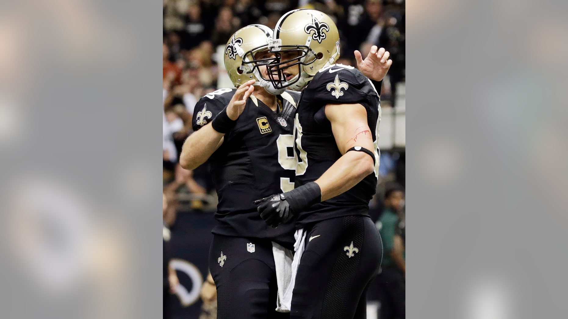 New Orleans Saints quarterback Drew Brees (9) congratulated tight end Jimmy Graham after Graham's touchdown reception during the second half of an NFL football game against the Carolina Panthers Sunday, Dec. 30, 2012, in New Orleans. (AP Photo/Dave Martin)