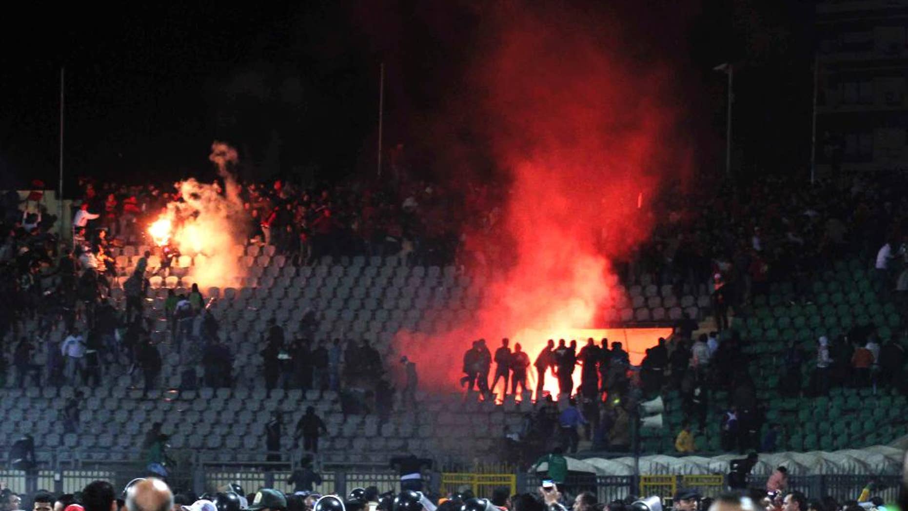 FILE - In this Feb. 1, 2012 file photo, Egyptian fans rush onto the field and clash in the stands following an Al-Ahly club soccer match against Al-Masry club at the soccer stadium in Port Said, Egypt. The riot killed at least 70 people. Security officials say police have arrested 22 people after hundreds went on a rampage in Egypt's coastal city of Port Said to protest death sentences for 10 residents for their part in the deadly 2012 soccer riot. (AP Photo, File)