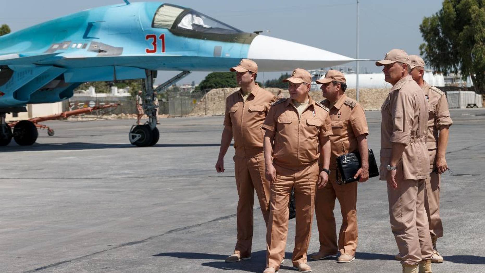 FILE - In this Saturday, June 18, 2016 file photo, Russian Defense Minister Sergei Shoigu, second left, visits the Hemeimeem air base in Syria. Shoigu said on Thursday, July 28, 2016 that Russia and the Syrian government will open humanitarian corridors and offer a way-out for Islamic State fighters wanting to lay down their arms. (Vadim Savitsky/Russian Defense Ministry Press Service Pool Photo via AP, file)