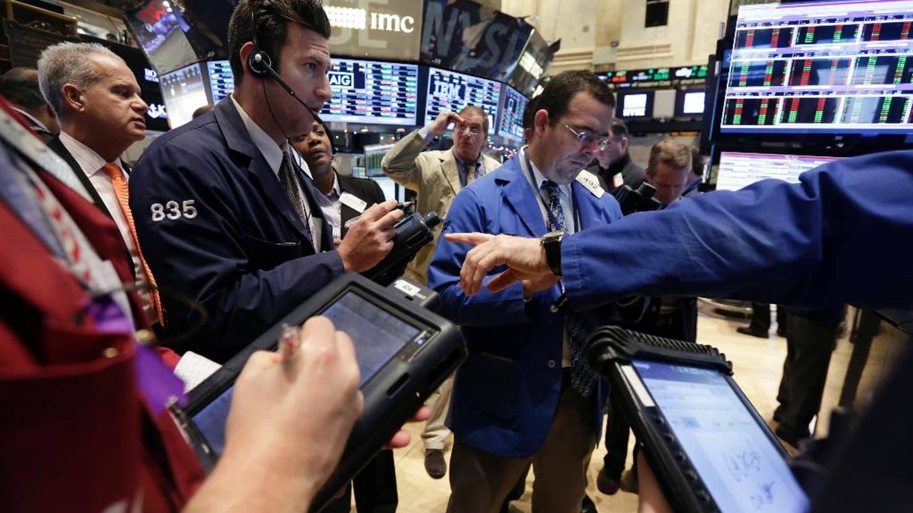 Traders gather at a post on the floor of the New York Stock Exchange Tuesday, Jan. 6, 2015. The U.S. stock market is edging higher in early trading as the price of oil extends its slump. (AP Photo/Richard Drew)