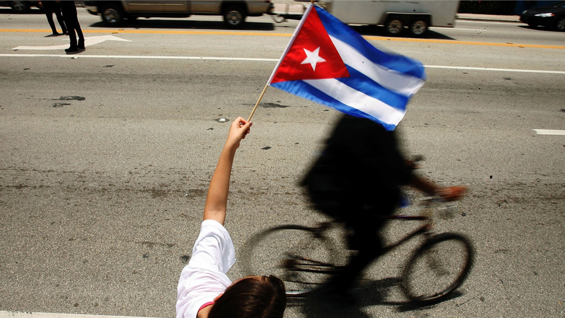 MIAMI - AUGUST 1: Ana Maria Acevedo, 10, waves a Cuban flag along the famous Calle Ocho in the Little Havana neighborhood August 1, 2006 in Miami, Florida. Acevedo immigrated to the U.S. from Cuba in 2000. Cuban Americans were celebrating the news that Fidel Castro had turned over power to his younger brother, Raul Castro, while he undergoes medical treatment for intestinal bleeding. (Photo by Chip Somodevilla/Getty Images)