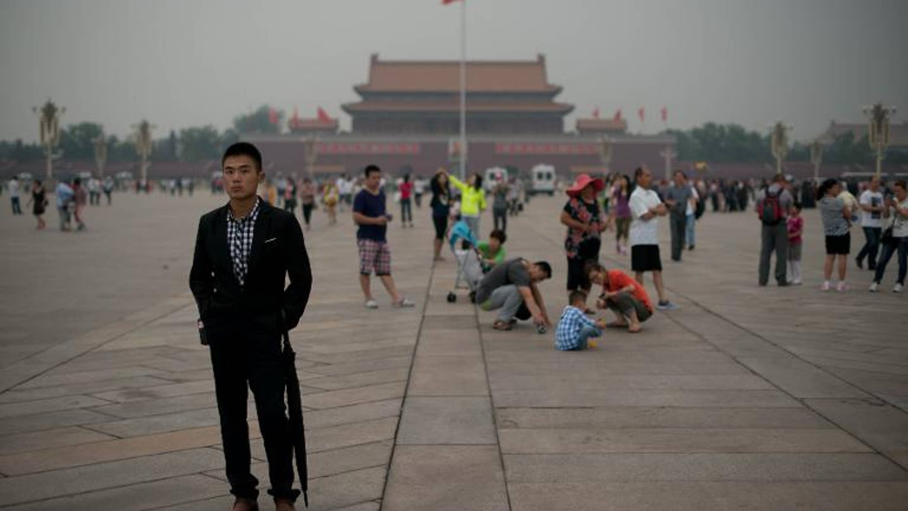 A plain-clothes policeman (L) at Tiananmen square in Beijing on June 4, 2013.