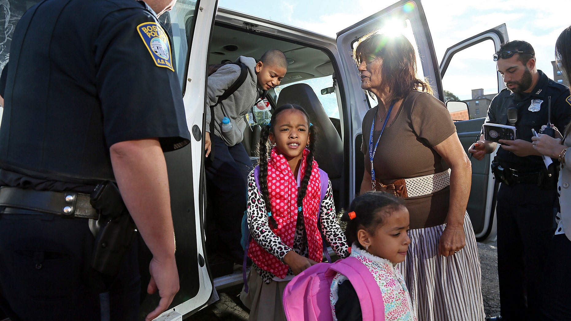 School children arrive in a Boston police van at the William Blackstone Elementary school after school bus drivers went on strike Tuesday, Oct. 8, 2013. The city scrambled to find any way to get students to class after about 600 of the 700 drivers who work for the city’s bus contractor unexpectedly went on strike, affecting about 33,000 students. (AP Photo/Boston Herald, Mark Garfinkel) MANDATORY CREDIT