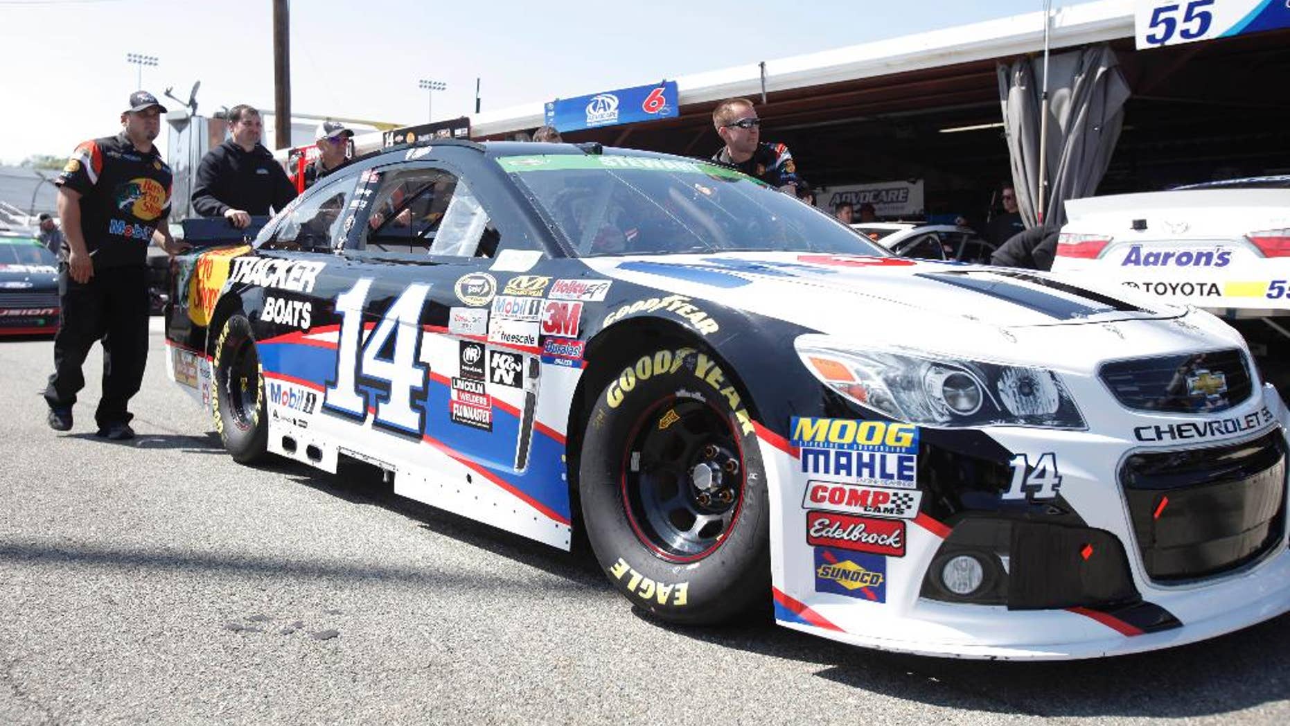 The pit crew for NASCAR Sprint Cup Series driver Tony Stewart (14) push his car to the inspection station at Richmond International Raceway in Richmond, Va., Friday, April 24, 2015. (AP Photo/Scott P. Yates)