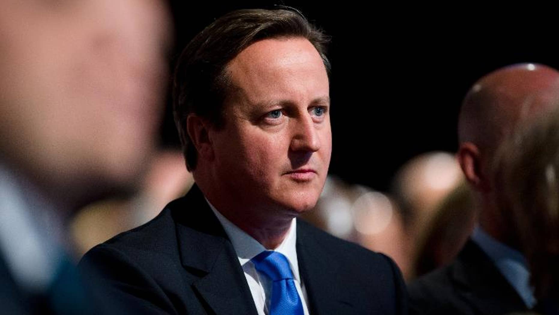 British Prime Minister David Cameron listens to a speech by London Mayor Boris Johnson at the annual Conservative Party Conference in Manchester, north-west England, on October 1, 2013