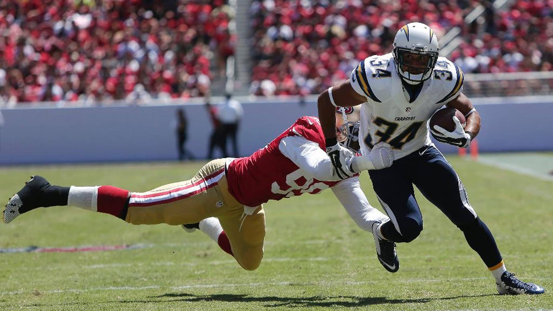 San Diego Chargers running back Donald Brown (34) runs from San Francisco 49ers linebacker Aldon Smith during the first quarter of an NFL preseason football game in Santa Clara, Calif., Sunday, Aug. 24, 2014. (AP Photo/Marcio Jose Sanchez)