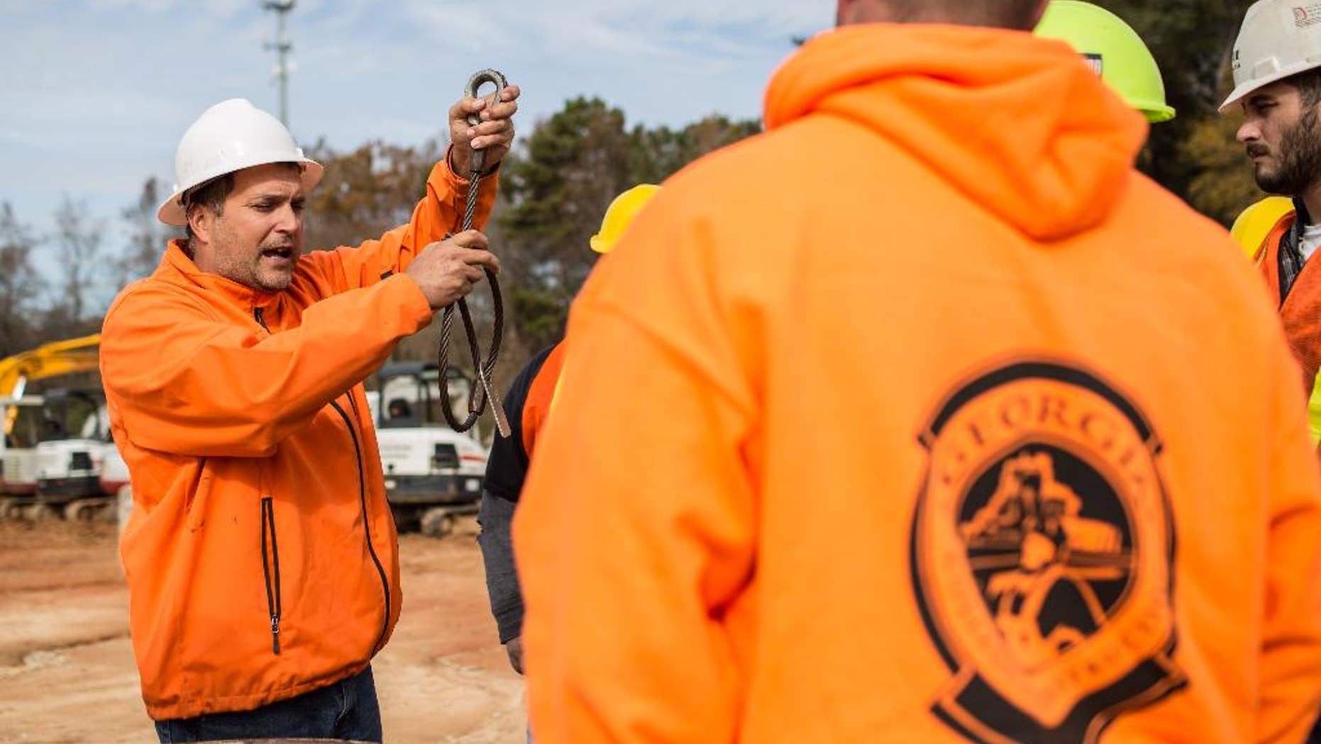 In this Nov. 25, 2014 photo, instructor Jason Amoroso, left, demonstrates how to properly use slings for lifting objects with a crane during a day of training at Georgia College of Construction, in Conyers, Ga. The U.S. Labor Department reports on the number of people who applied for unemployment benefits last week on Thursday, Dec. 11, 2014. (AP Photo/Branden Camp)