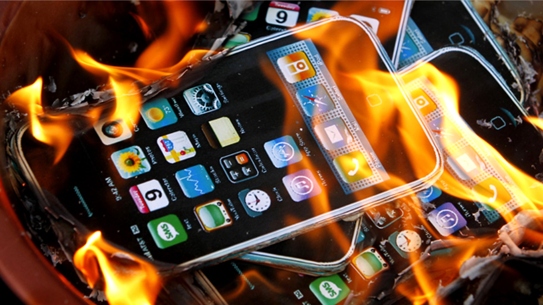 May 25, 2010: Cardboard cutouts resembling iPhones are in flames after they were set on fire by labor activists near the Foxconn office in Hong Kong, following a string of deaths at the world's largest contract maker of electronics.