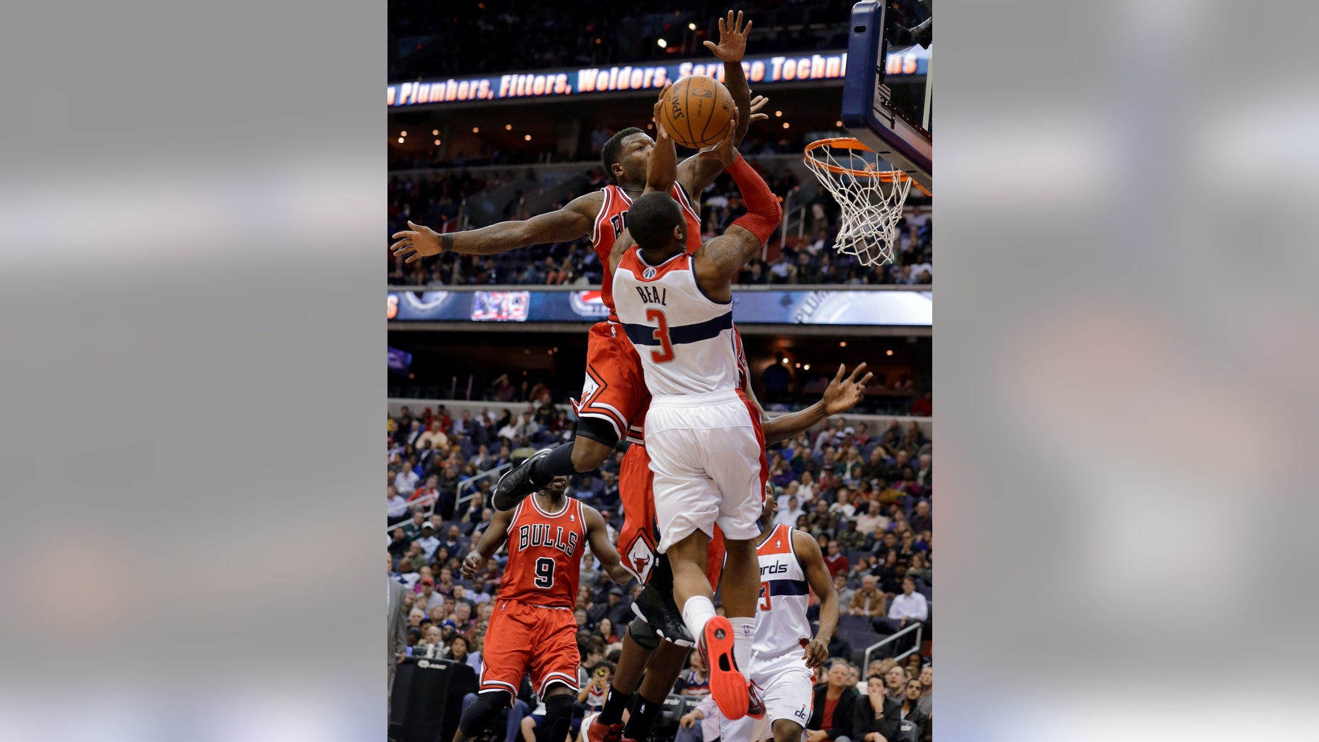 Washington Wizards guard Bradley Beal (3) goes for a shot as Chicago Bulls guard Nate Robinson (2) defends duirng the second half of an NBA basketball game Tuesday, April 2, 2013, in Washington. The Wizards won 90-86. (AP Photo/Alex Brandon)