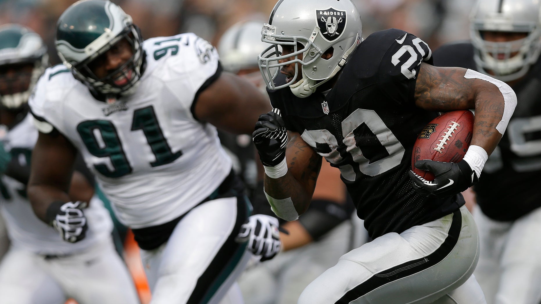 Oakland Raiders running back Darren McFadden (20) runs against Philadelphia Eagles defensive end Fletcher Cox (91) during the second quarter of an NFL football game in Oakland, Calif., Sunday, Nov. 3, 2013. (AP Photo/Marcio Jose Sanchez)